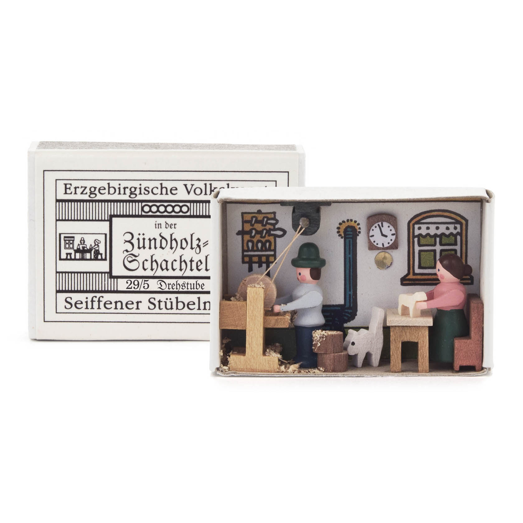 Miniatur-Szene in einer Zündholzschachtel: Zwei Figuren an einem Tisch mit Drehbank, im Hintergrund eine Uhr und eine Ofenattrappe. im Dregeno Online Shop günstig kaufen