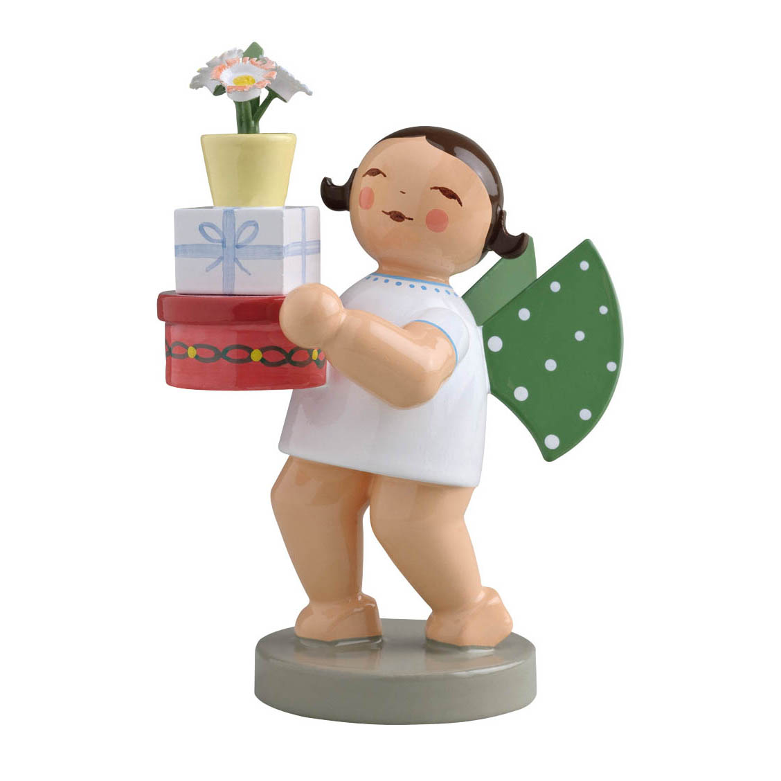 Ein stilisierter Engel mit grünen Flügeln hält drei Geschenkboxen, gekrönt von einem Blumentopf, in den Händen. im Dregeno Online Shop günstig kaufen