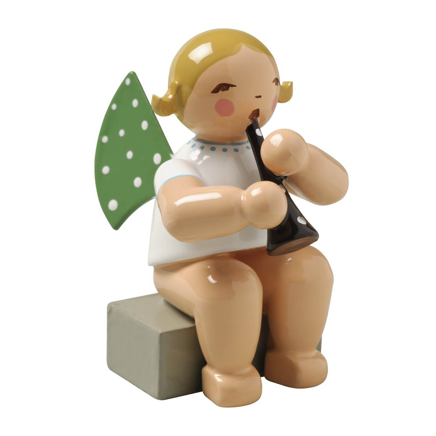 Engelsfigur mit kurzen blonden Haaren und grünen Flügeln mit weißen Punkten. Sitzt auf grau quadratischem Sockel und spielt Klarinette. im Dregeno Online Shop günstig kaufen