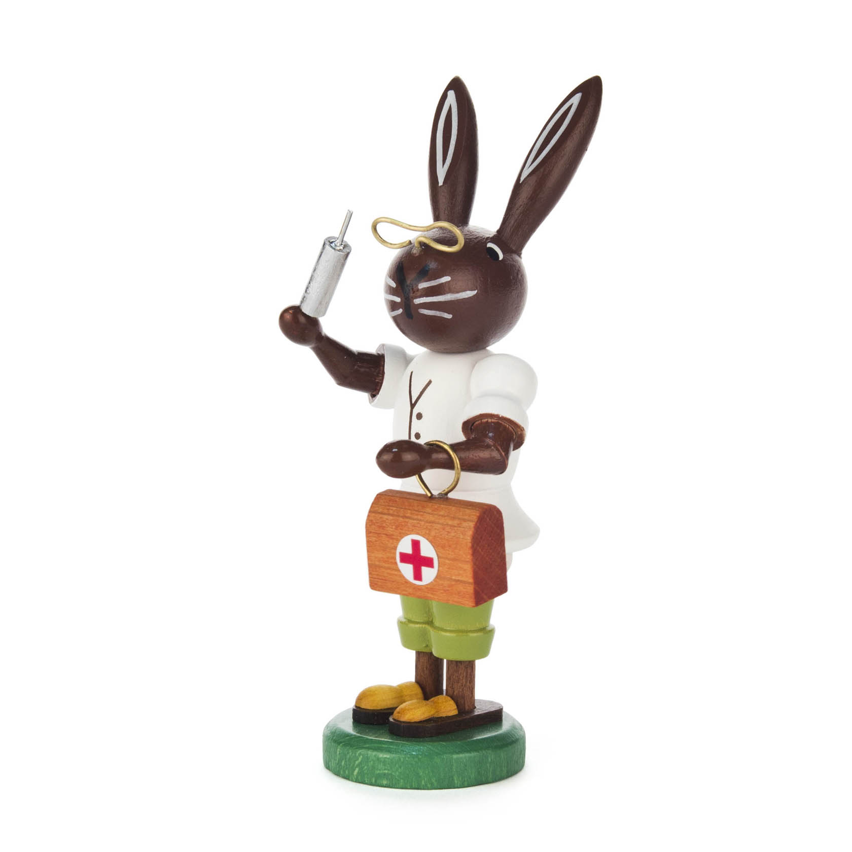 A figurine of a bunny dressed as a doctor, holding a syringe in one hand and a medical bag with a red cross in the other. im Dregeno Online Shop günstig kaufen
