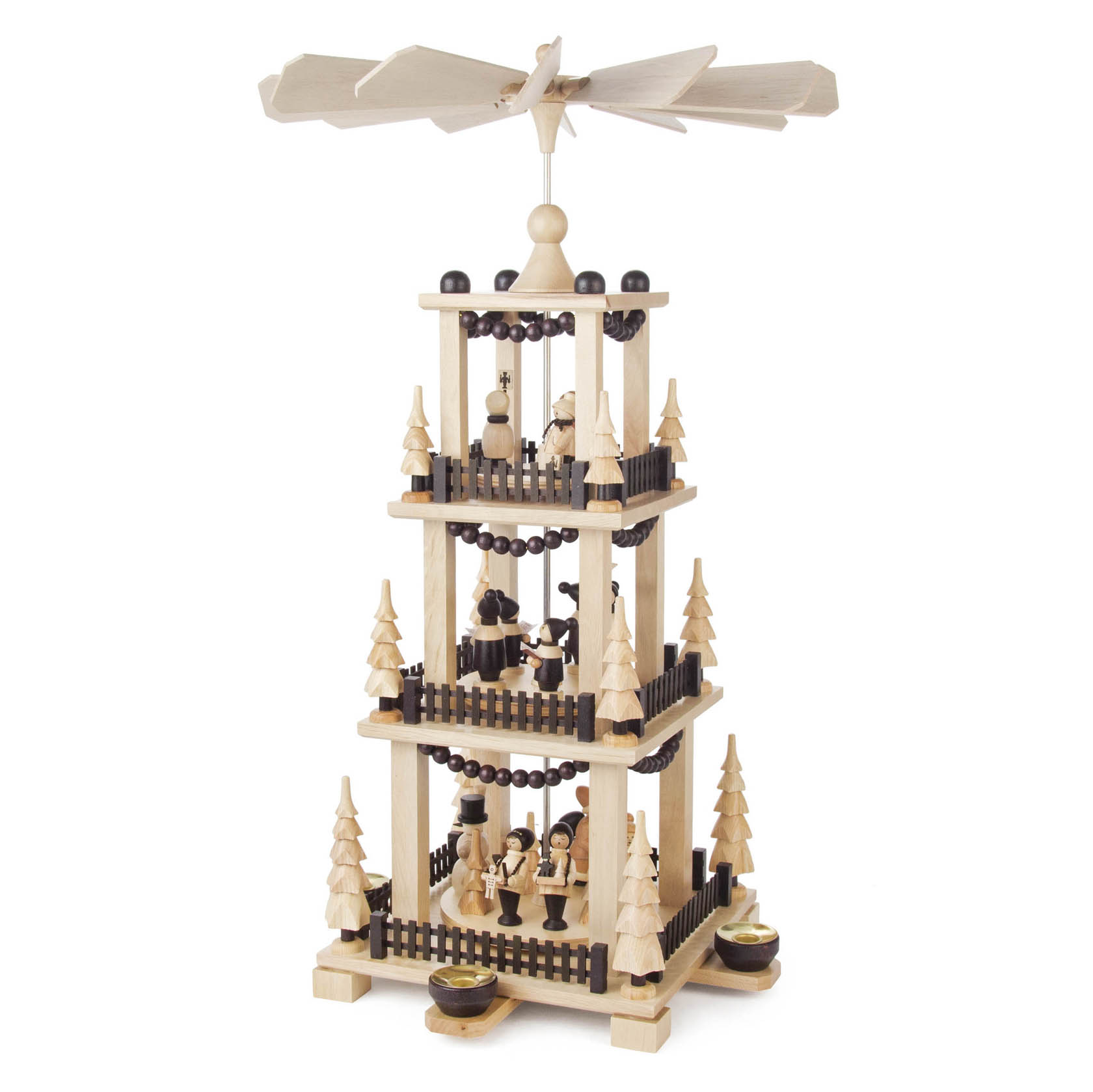 Holzpyramide mit drei Etagen, dekoriert mit kleinen Holzfiguren und Bäumen. Oben drehen sich Flügel, angetrieben durch Kerzenwärme an der Basis.