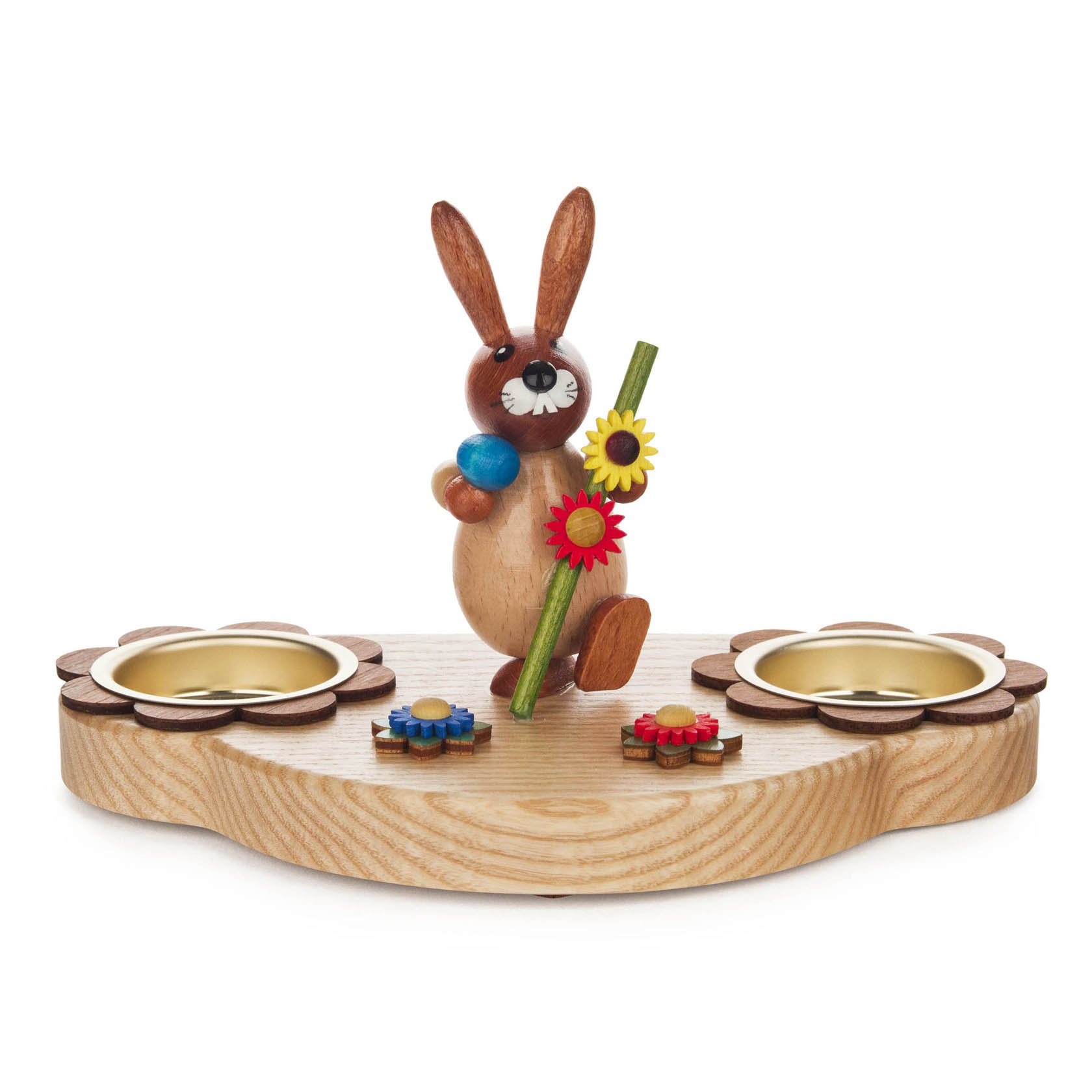 Ein Teelichthalter in Form einer hölzernen Basis mit zwei Kerzenhaltern und einer Hasenfigur in der Mitte. Der Hase hält einen Wanderstab mit Blumen. im Dregeno Online Shop günstig kaufen