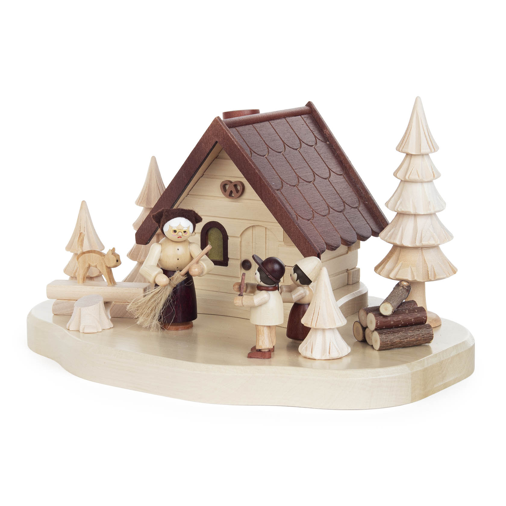 Holzfigurenszene mit dem Hexenhäuschen aus 'Hänsel und Gretel', zeigt eine Hexe, Hänsel und Gretel vor einem detailreich gestalteten kleinen Haus umgeben von Tannenbäumen.