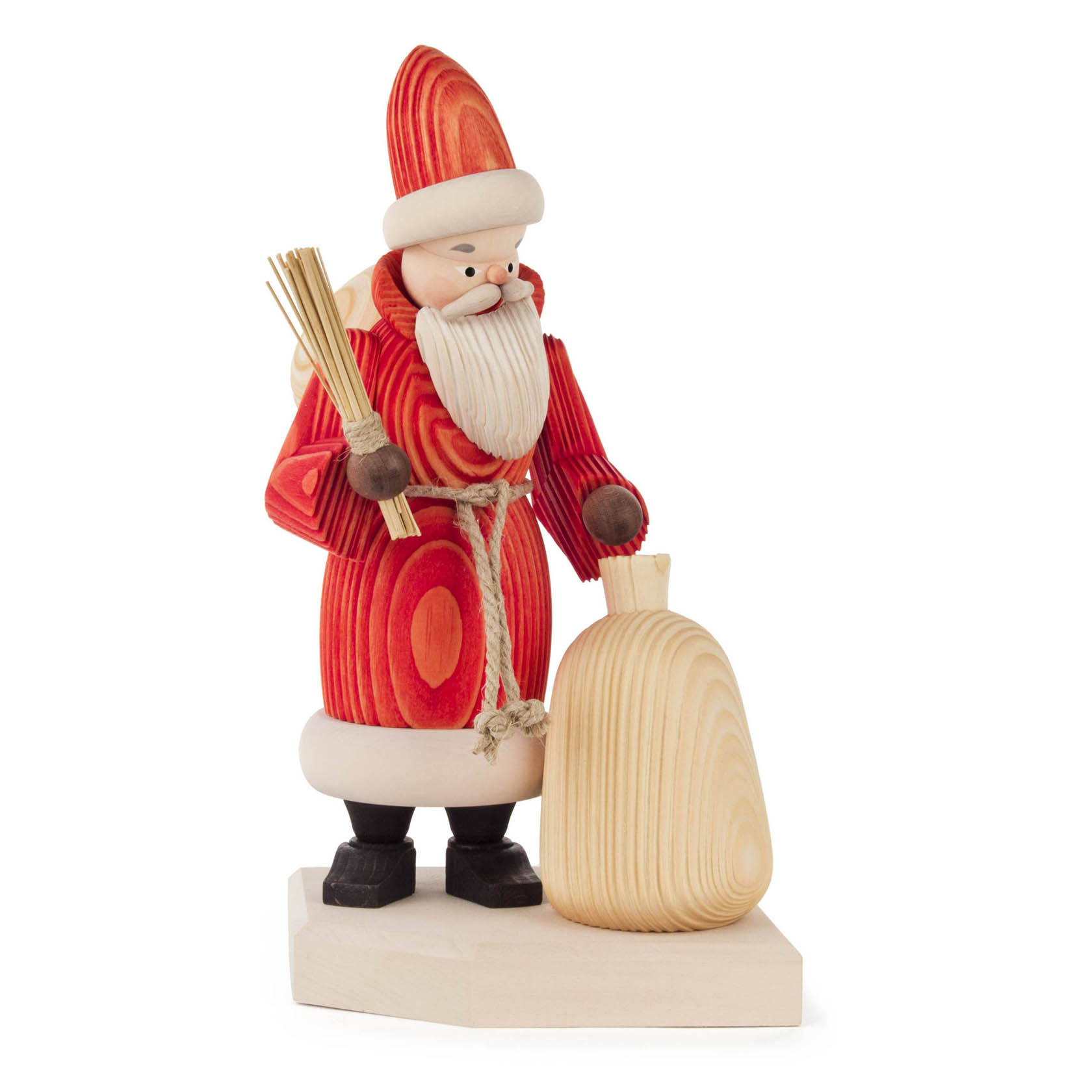 Holzfigur eines Weihnachtsmannes mit rotem Mantel und weißem Bart, der einen Sack trägt. Er hält auch ein Bündel Zweige in der Hand.