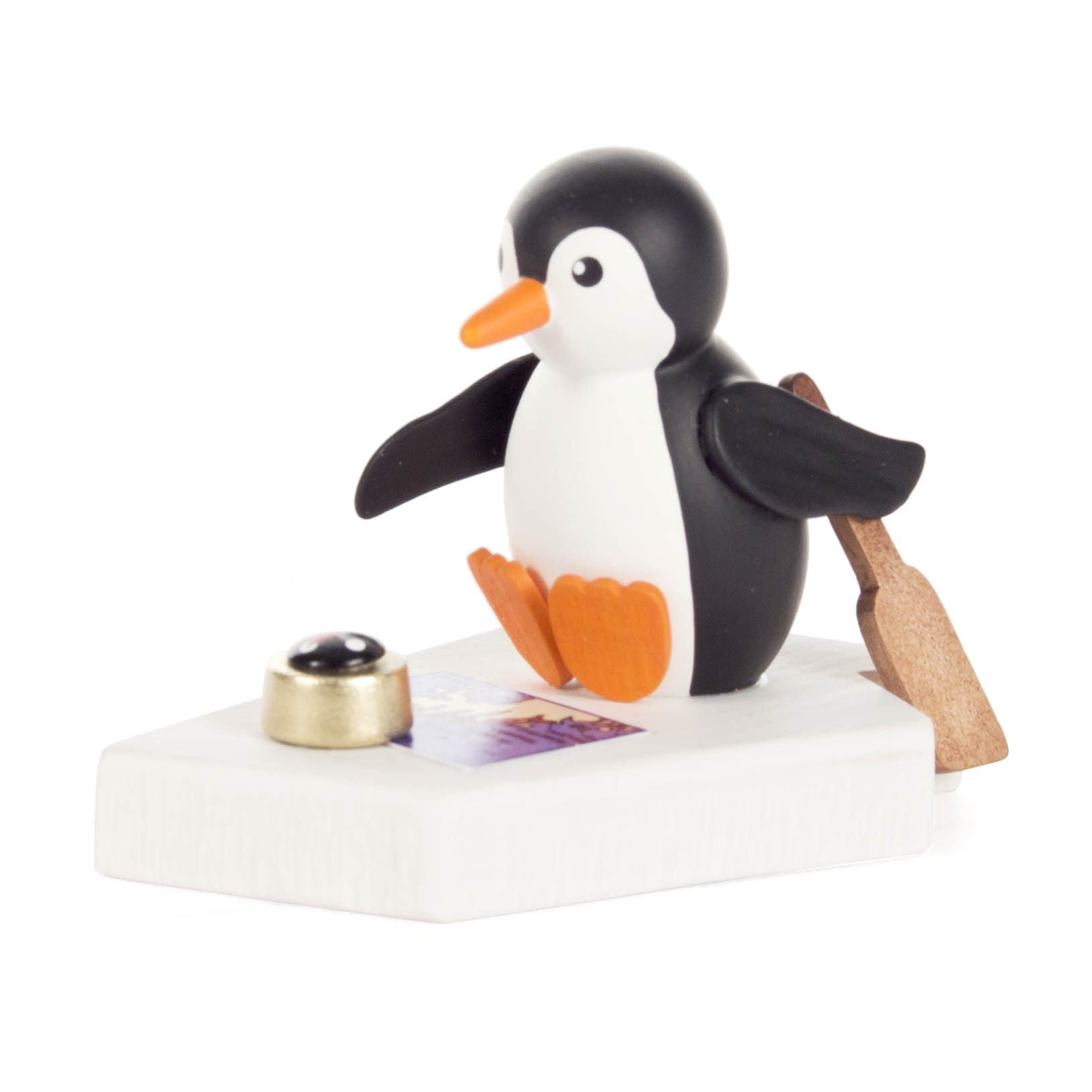 Eine kleine Pinguinfigur mit orangefarbenen Füßen und Schnabel sitzt auf einer weißen Plattform mit Steuerruder. im Dregeno Online Shop günstig kaufen