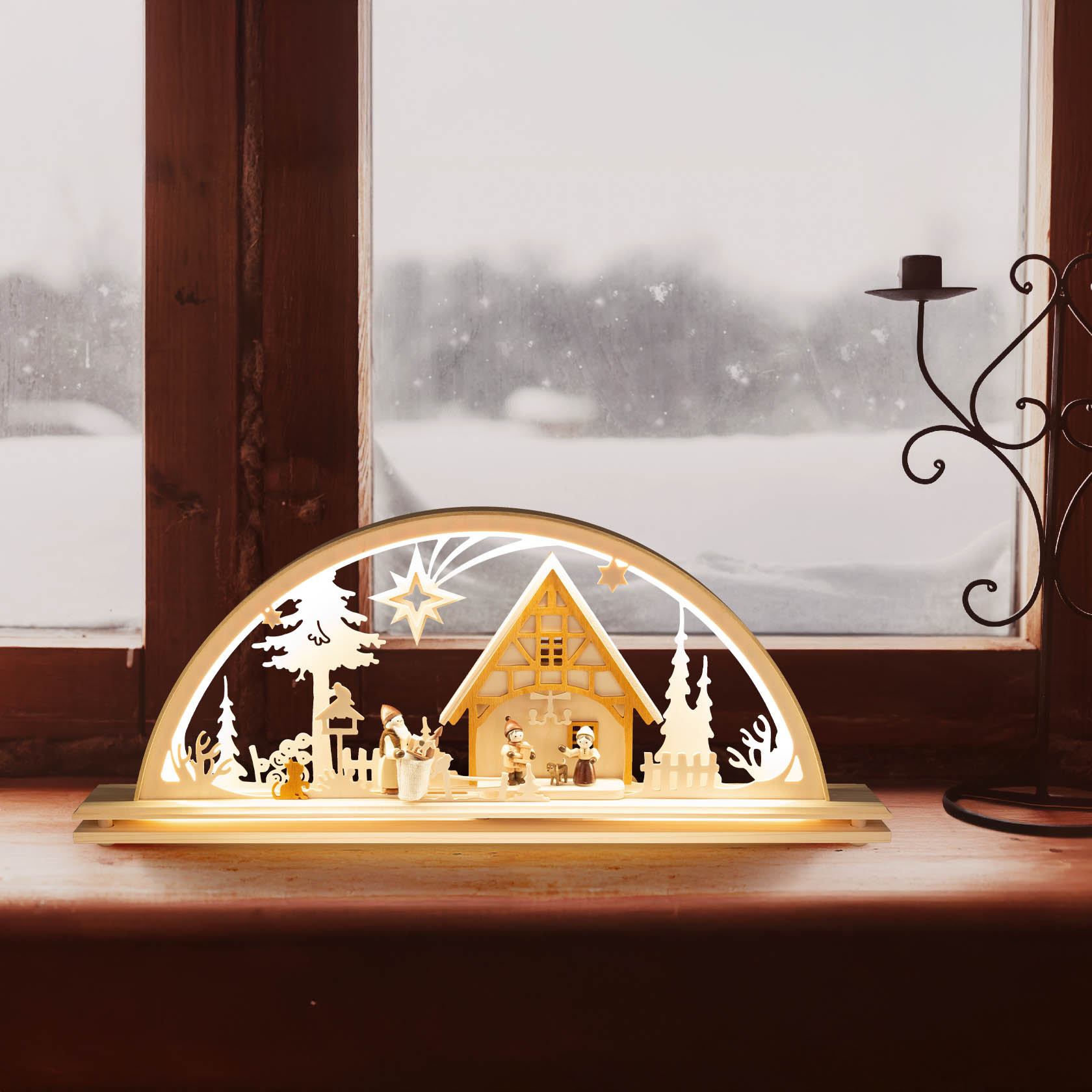 Ein elektrisch beleuchteter Schwibbogen mit LED, der eine weihnachtliche Bescherungsszene darstellt. Zu sehen ist ein Haus mit Figuren und Stern als Dekor.