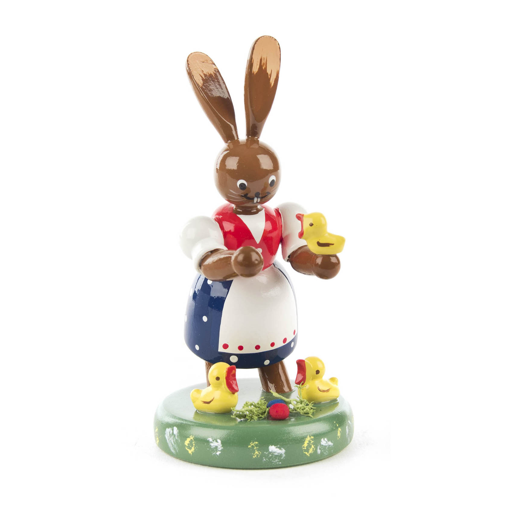 Holzfigur einer Häsin mit drei gelben Küken zu ihren Füßen, die ein weiteres Küken in ihrer linken Hand hält. Die Häsin trägt ein traditionelles Kleid. im Dregeno Online Shop günstig kaufen