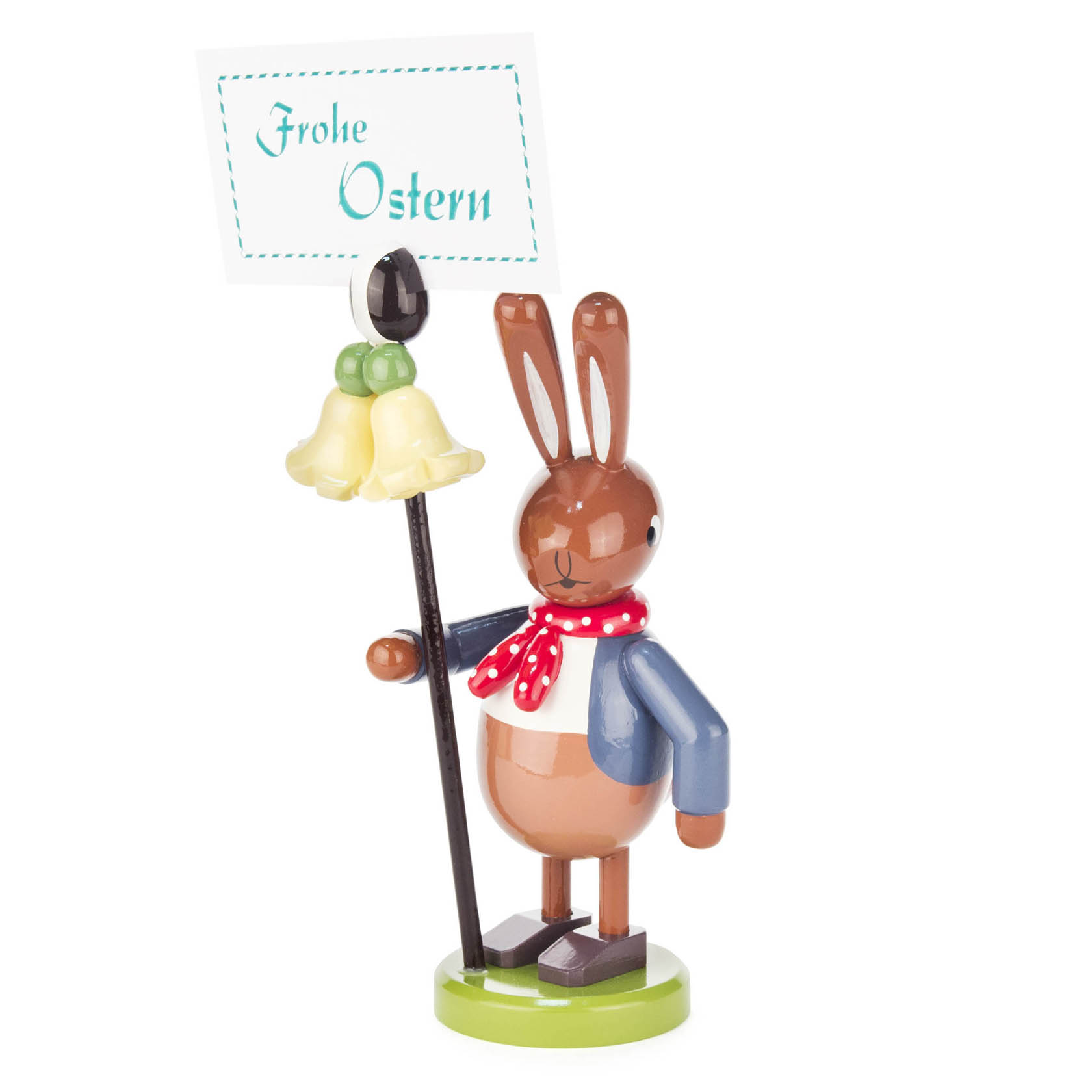 Holzhase mit rotem Schal und blauem Jackett, hält Schild 'Frohe Ostern' und große gelbe Blume in den Händen. im Dregeno Online Shop günstig kaufen