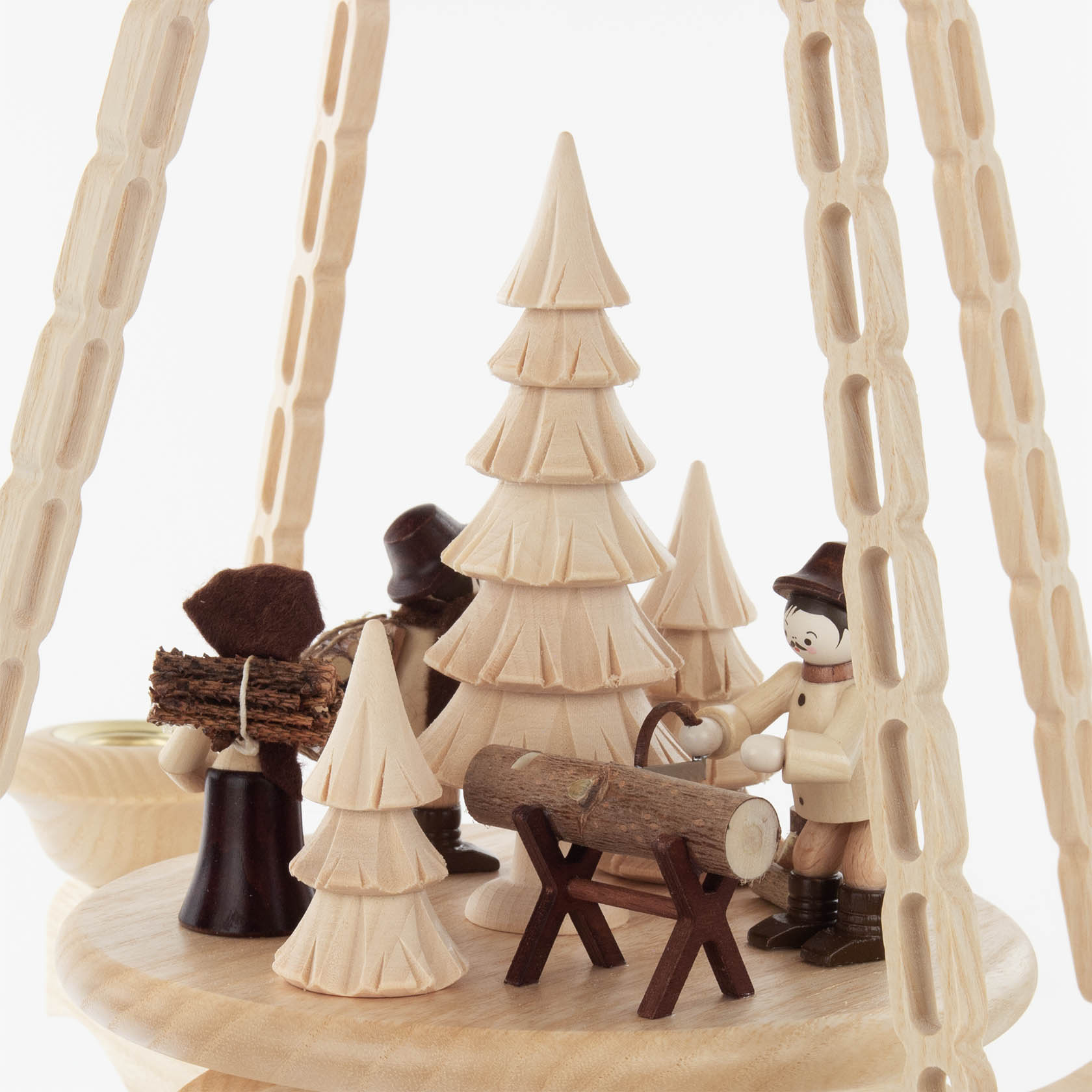 Holzpyramide mit Waldarbeitern und Tannenbäumen, einer trägt Holz, ein anderer bearbeitet einen Holzstamm. Figuren in traditionellen Trachten.