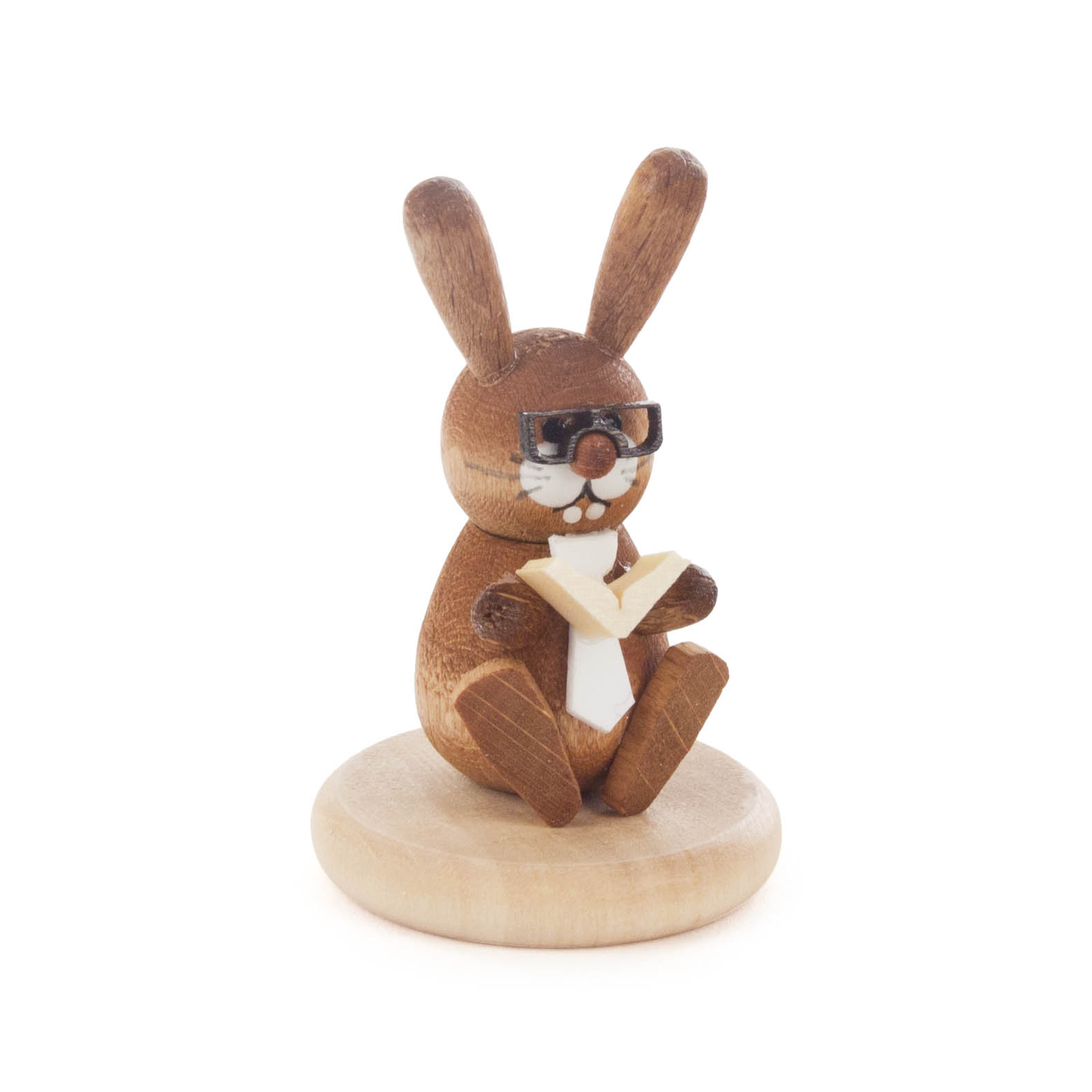 Holzfigur eines braunen Hasen mit Brille und Buch, sitzt auf hellem Sockel. Hase trägt Krawatte, das Buch ist geöffnet, die Figur ist farbig lasiert. im Dregeno Online Shop günstig kaufen