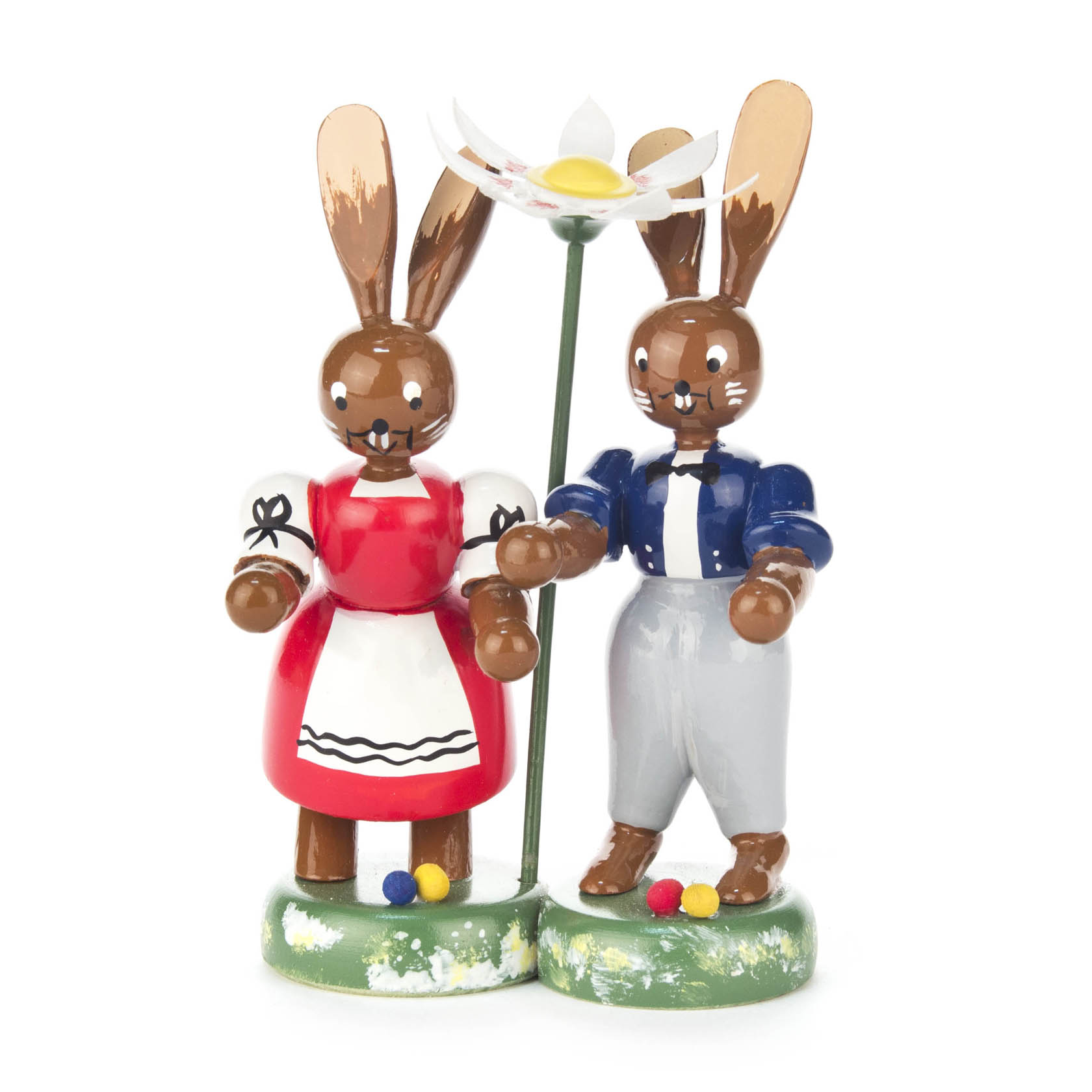 Zwei Hasenfiguren, ein weiblicher mit rotem Kleid und ein männlicher mit blauer Jacke, stehen nebeneinander auf einem grünen Sockel mit einer Blume. im Dregeno Online Shop günstig kaufen