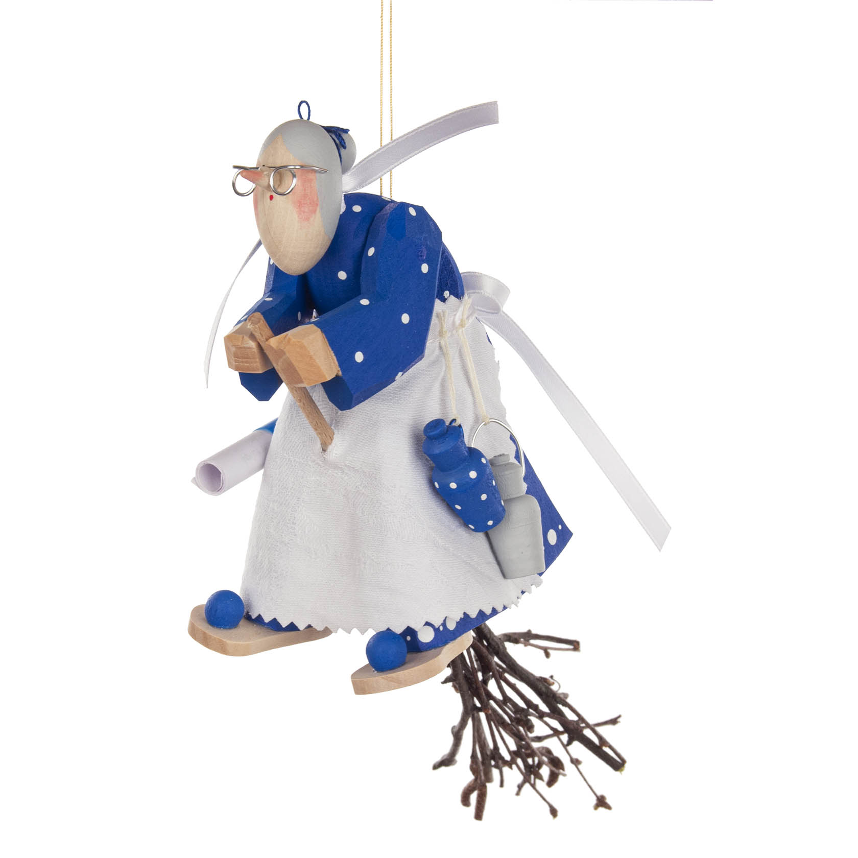 Eine geschnitzte Küchenhexe in blau-weißem Kleid, sitzt auf einem Besen, mit Brille und Schürze, zum Aufhängen.