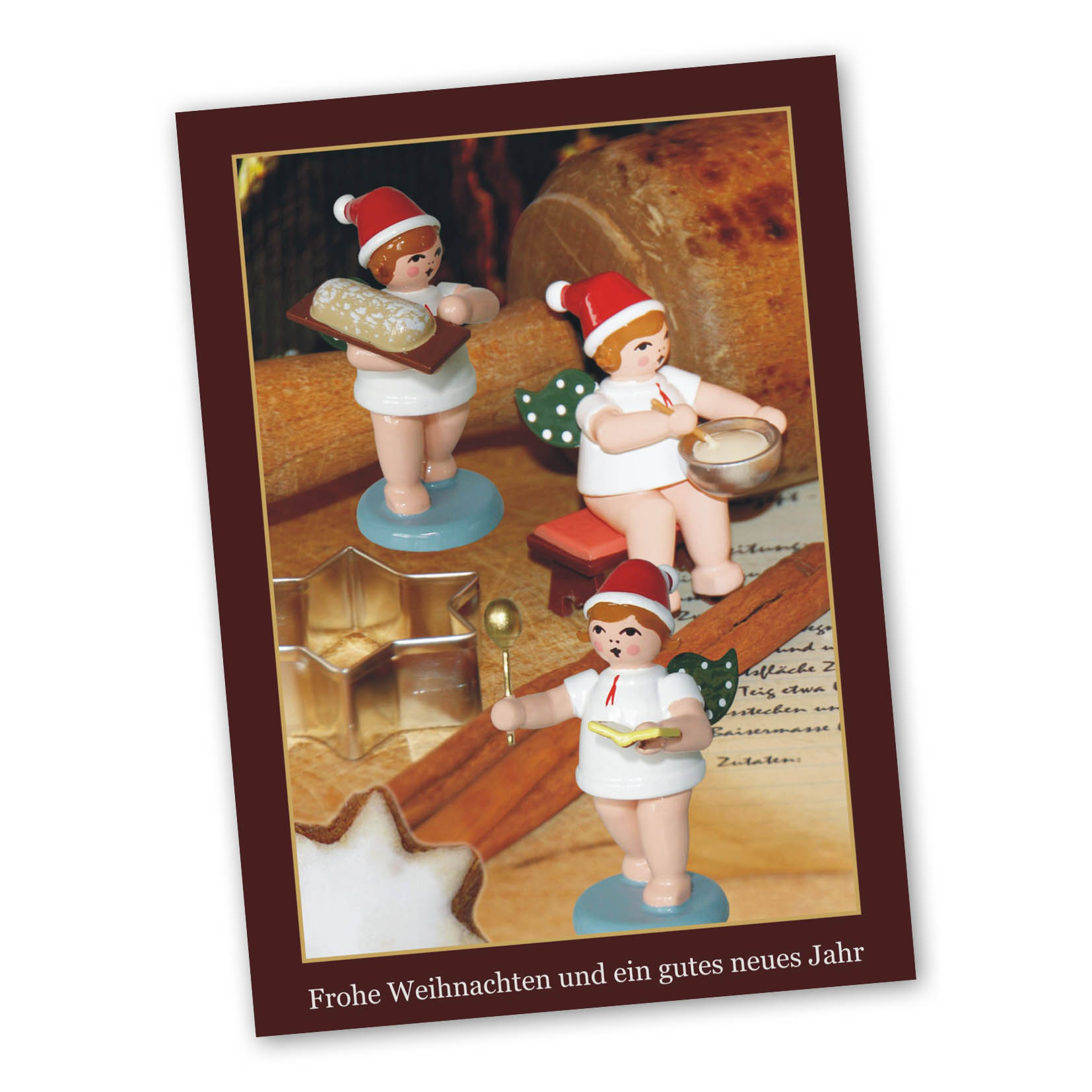 Three wooden angel figures in Santa hats baking cookies, holding dough, mixing bowl, and spoon, on a Christmas card. im Dregeno Online Shop günstig kaufen
