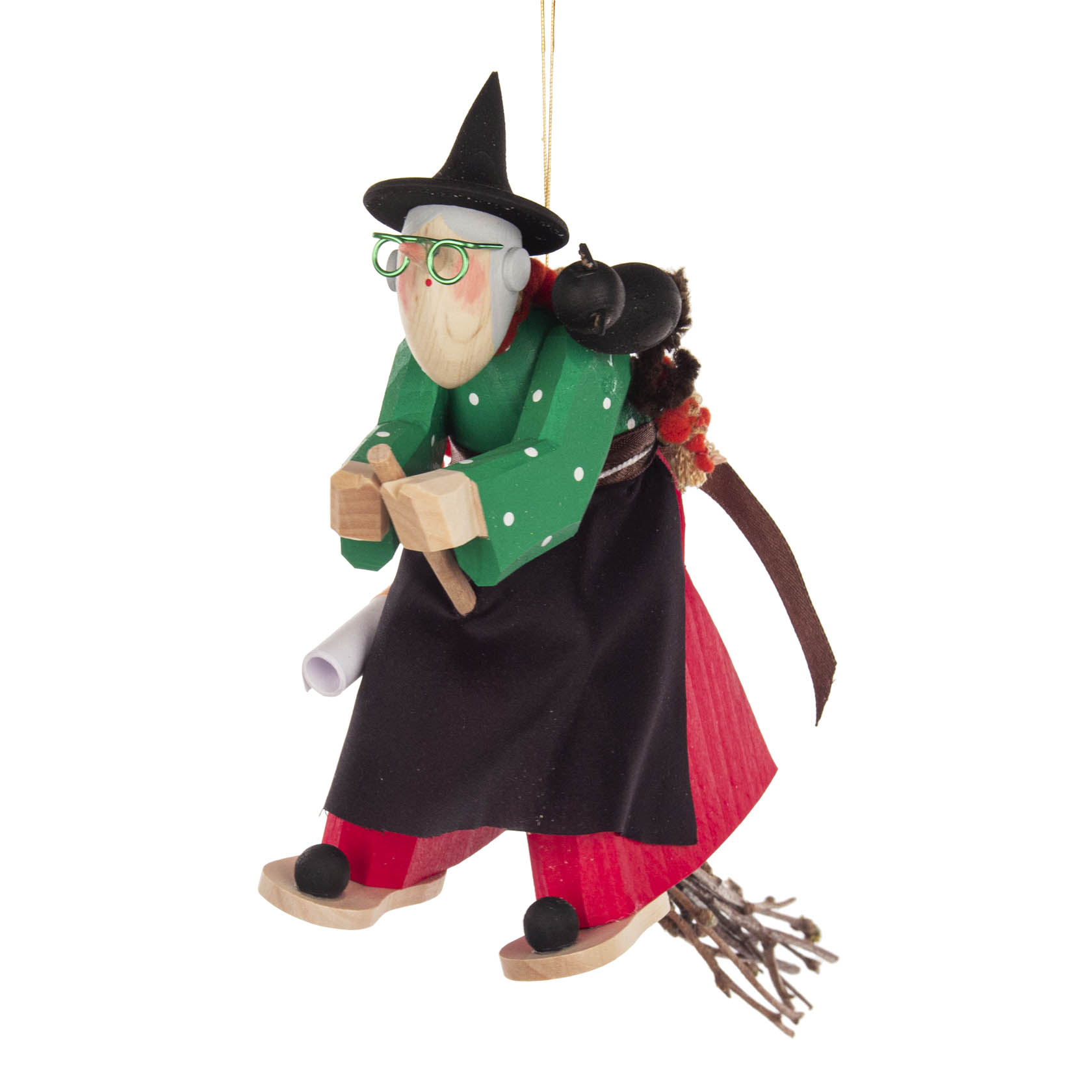 Holzgeschnitzte Figur einer fliegenden Hexe mit grünem Mantel, rotem Rock und schwarzem Hut, die auf einem Besen fliegt. Ein kleiner schwarzer Kater sitzt auf ihrem Rücken.