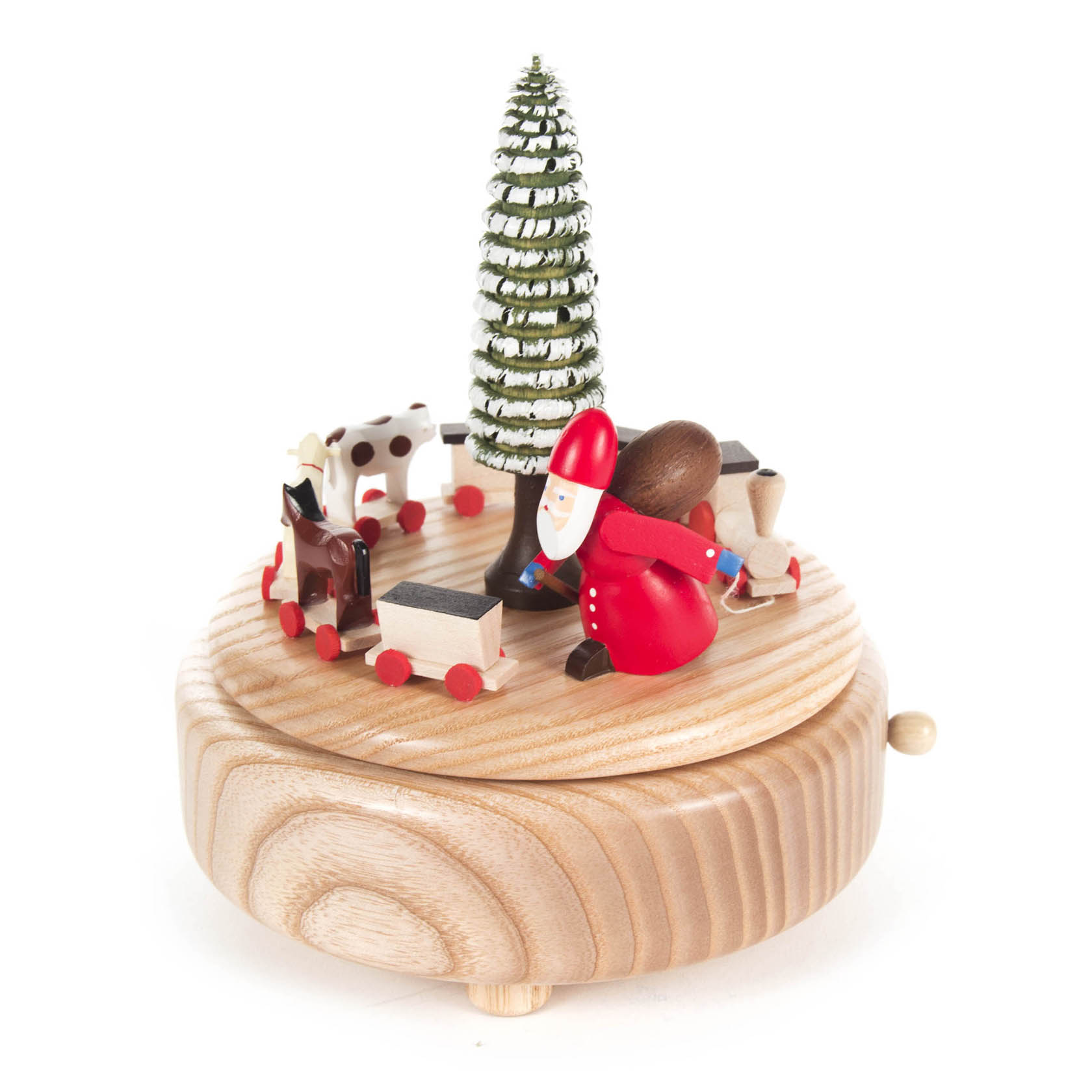Eine Spieldose zeigt den Weihnachtsmann in Rot neben einem grün-weißen Weihnachtsbaum, umgeben von einer kleinen Eisenbahn, einem Hund und einem weißen Reh.
