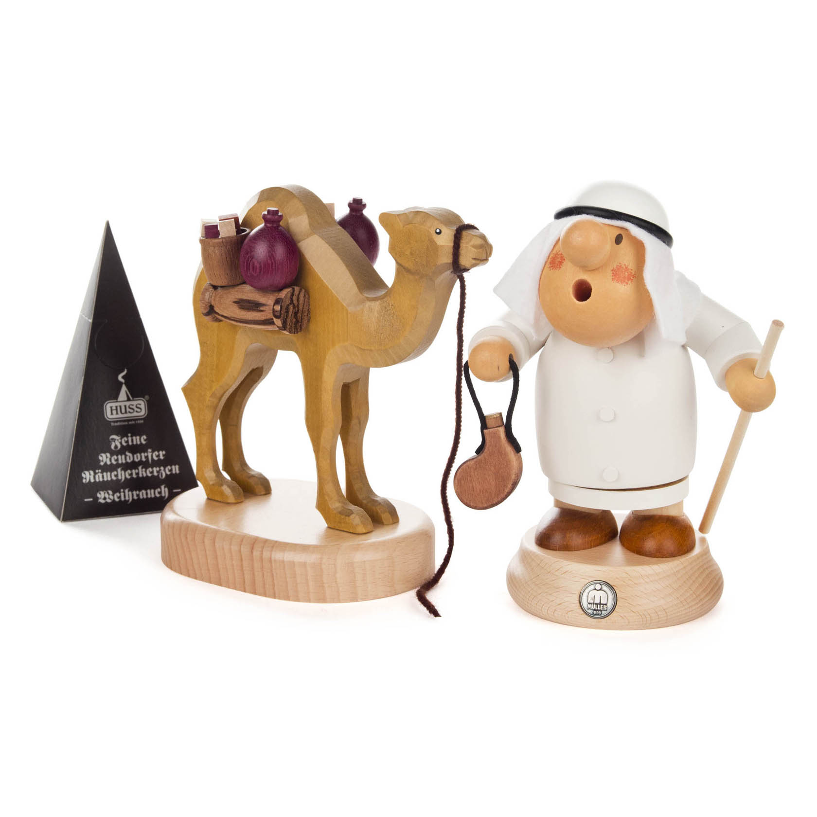 Ein handgeschnitzter Räuchermann im arabischen Stil mit weißem Gewand, schwarzem Kopftuch, Stock, Tasche und einem Kamel neben sich sowie Weihrauch-Räucherkerzen. im Dregeno Online Shop günstig kaufen