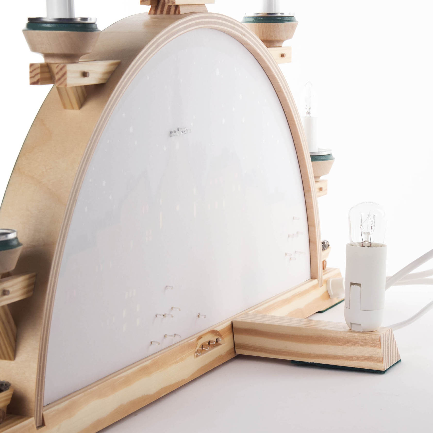 Ein elektrisch beleuchteter Schwibbogen mit Seiffener Dorfmotiv und Kurrende. Die Rückseite ist sichtbar mit Lichterfassung und Holzbogenstruktur.