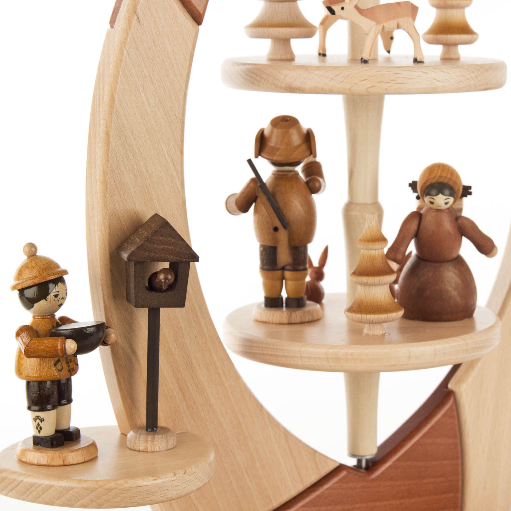 Holzpyramide in Form eines Segels mit geschnitzten Waldfiguren, darunter ein Förster, eine Frau, ein Reh und ein Vogelhäuschen.