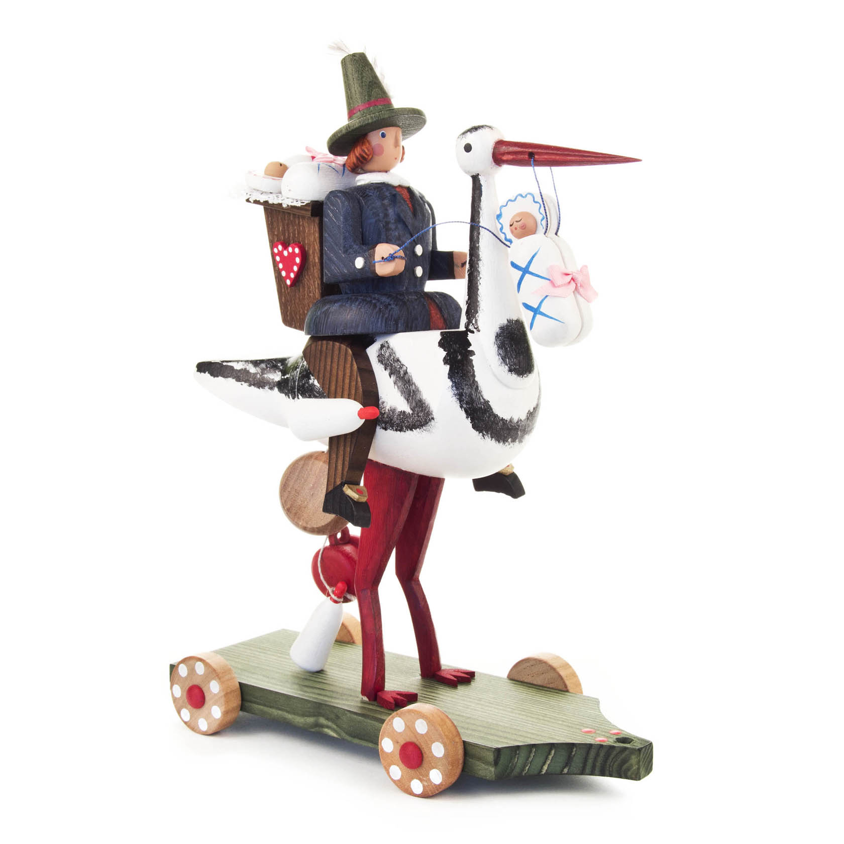 Ein handbemaltes Holzspielzeug zeigt eine Figur in traditioneller Tracht, die auf einem großen Storchenmodell sitzt, mit einem Korb am Rücken. im Dregeno Online Shop günstig kaufen