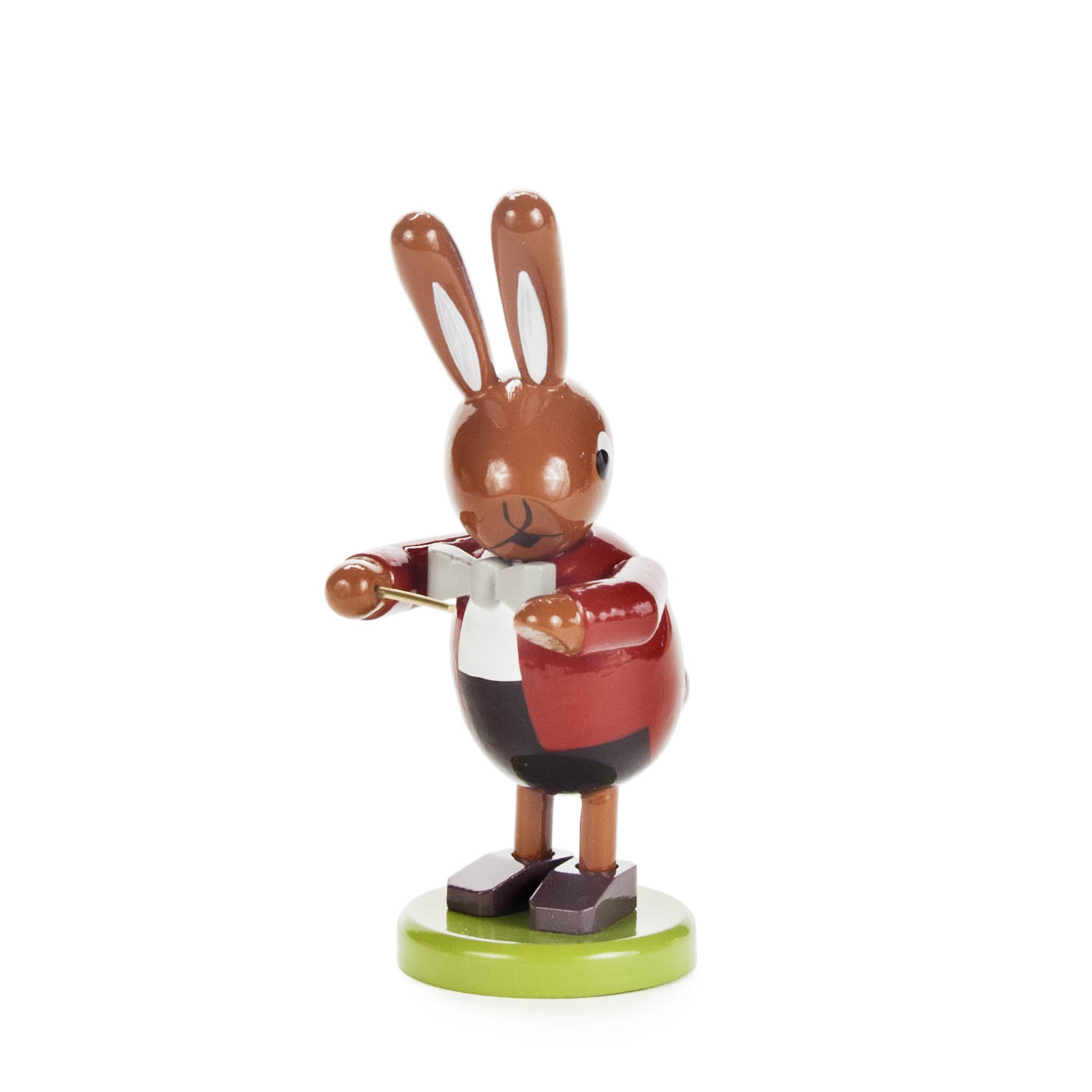 Kleine hölzerne Hasenfigur als Dirigent, mit roter Jacke, weißem Hemd, schwarzer Schleife und erhobenem Taktstock auf grünem Sockel. im Dregeno Online Shop günstig kaufen