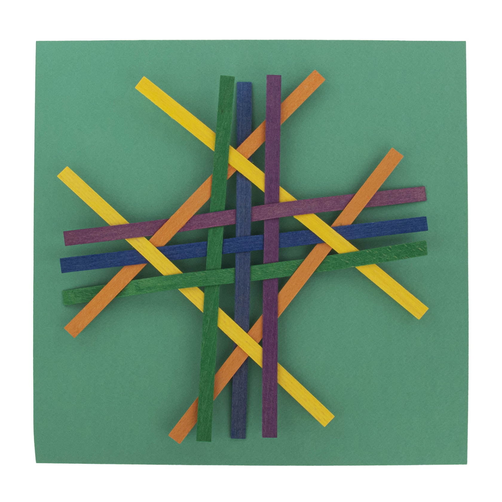 Multicolored wood sticks interwoven to form a symmetric, crisscrossed pattern on a green background.