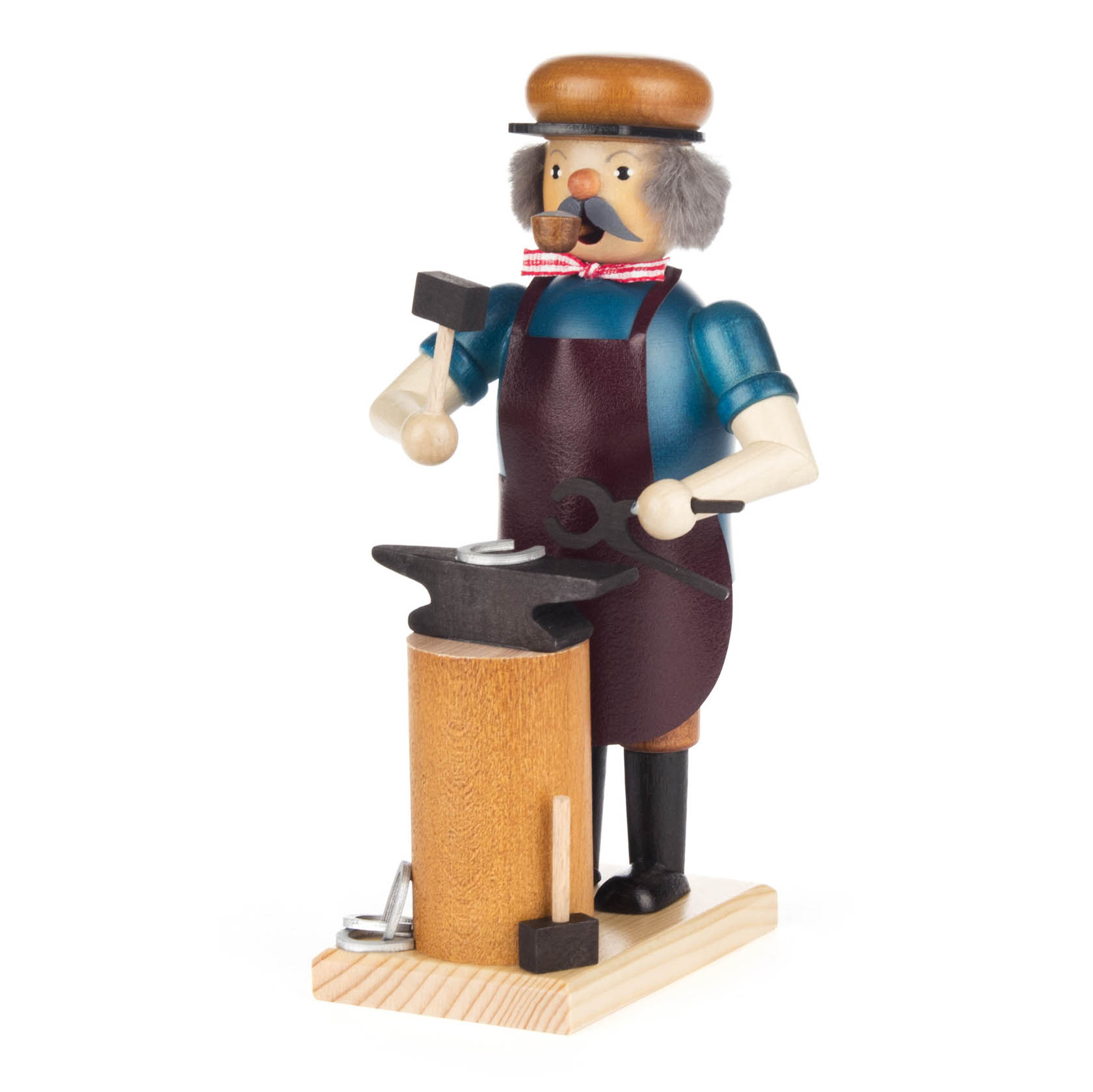 Ein Räuchermann in Form eines Schmieds steht auf einem Holzsockel. Er trägt eine blaue Hemd, dunkle Schürze und Metallhelm, hält einen Hammer und steht vor einem Amboss. im Dregeno Online Shop günstig kaufen