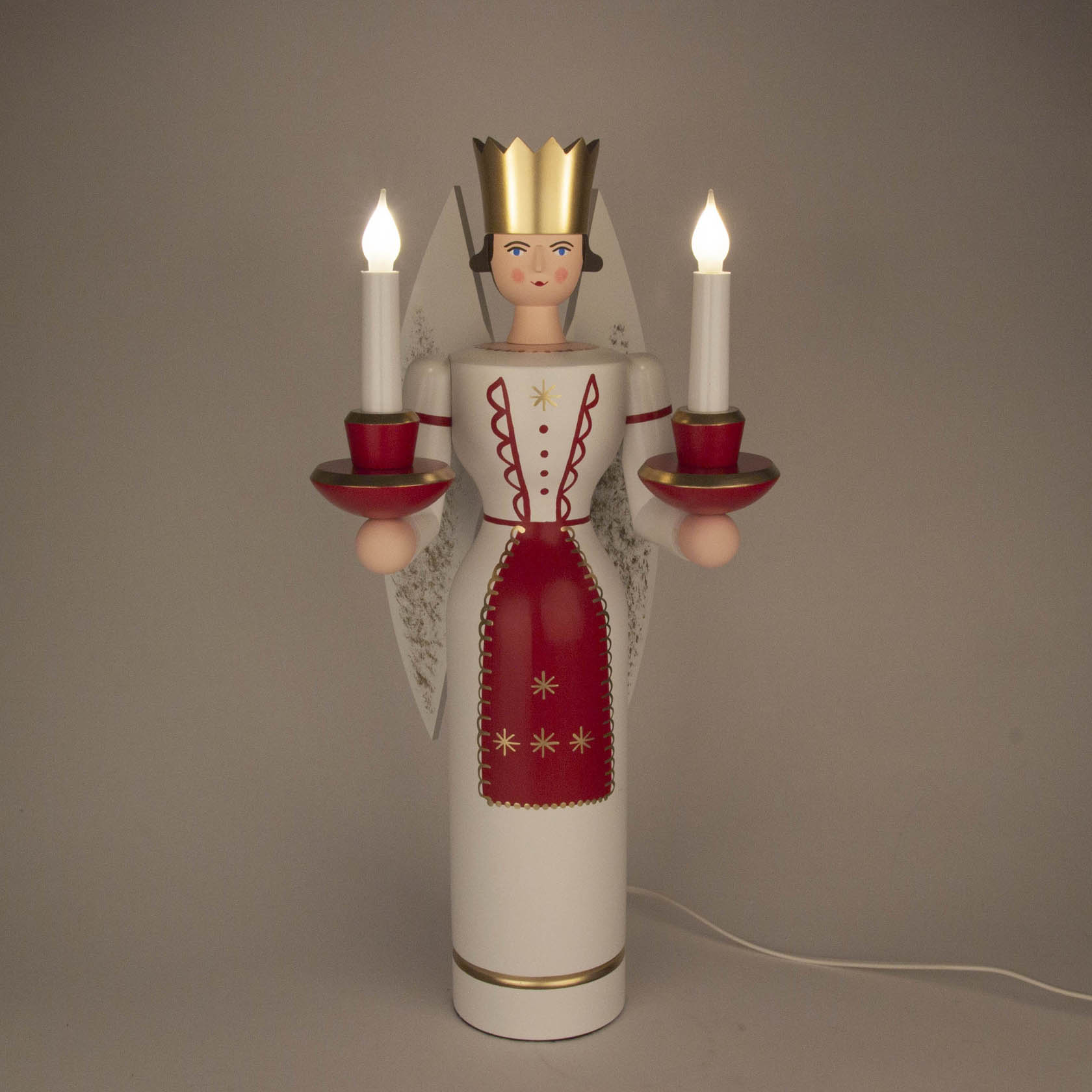 A 49cm tall colorful wooden angel figurine with a crown, holding a lit electric candle in each hand, standing upright with intricate red and gold detailing.