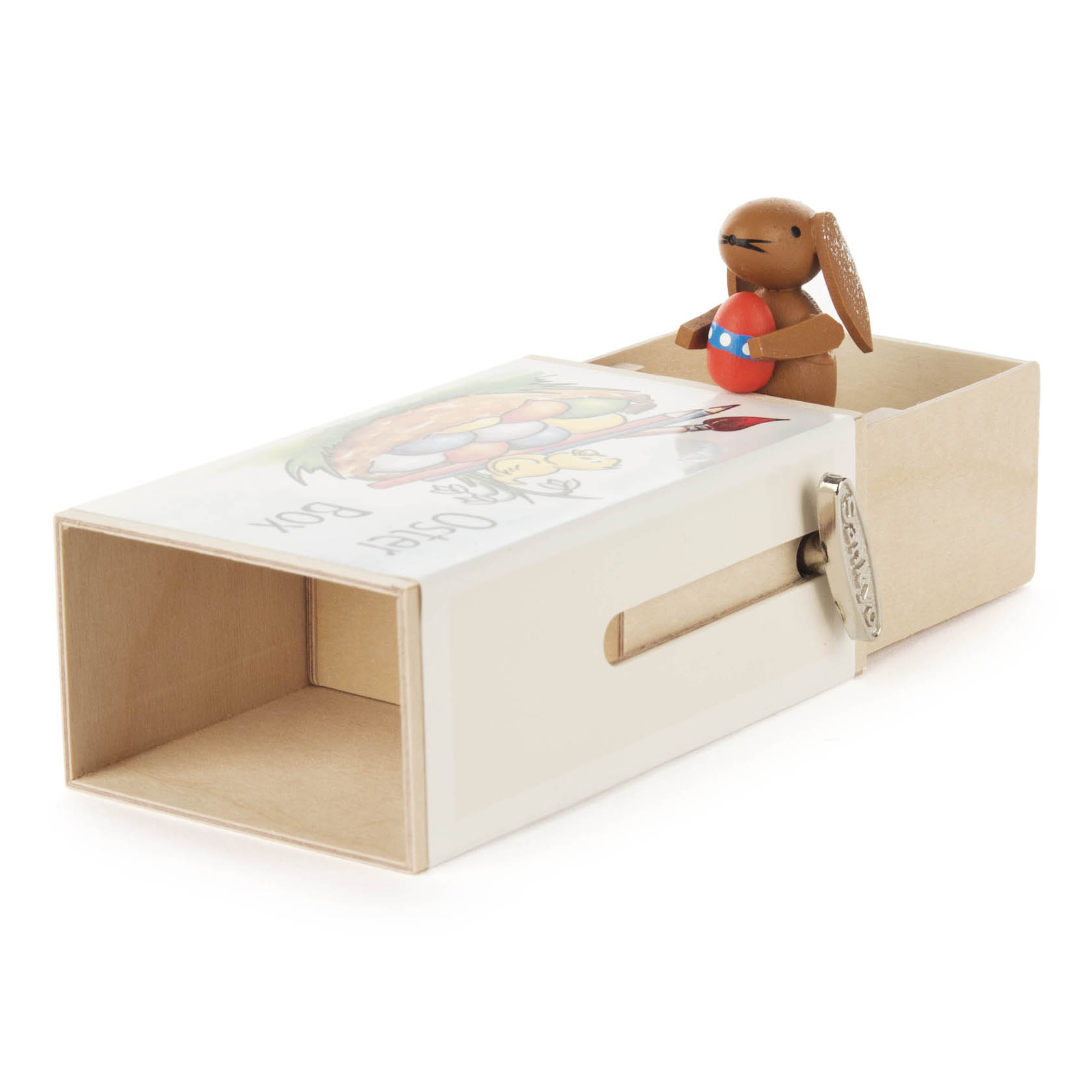 Schiebebox mit dem Motiv 'Oster-Box', aus der ein kleiner, bemalter Holz-Hase mit Osterei und Melodie-Spieler herausragt.