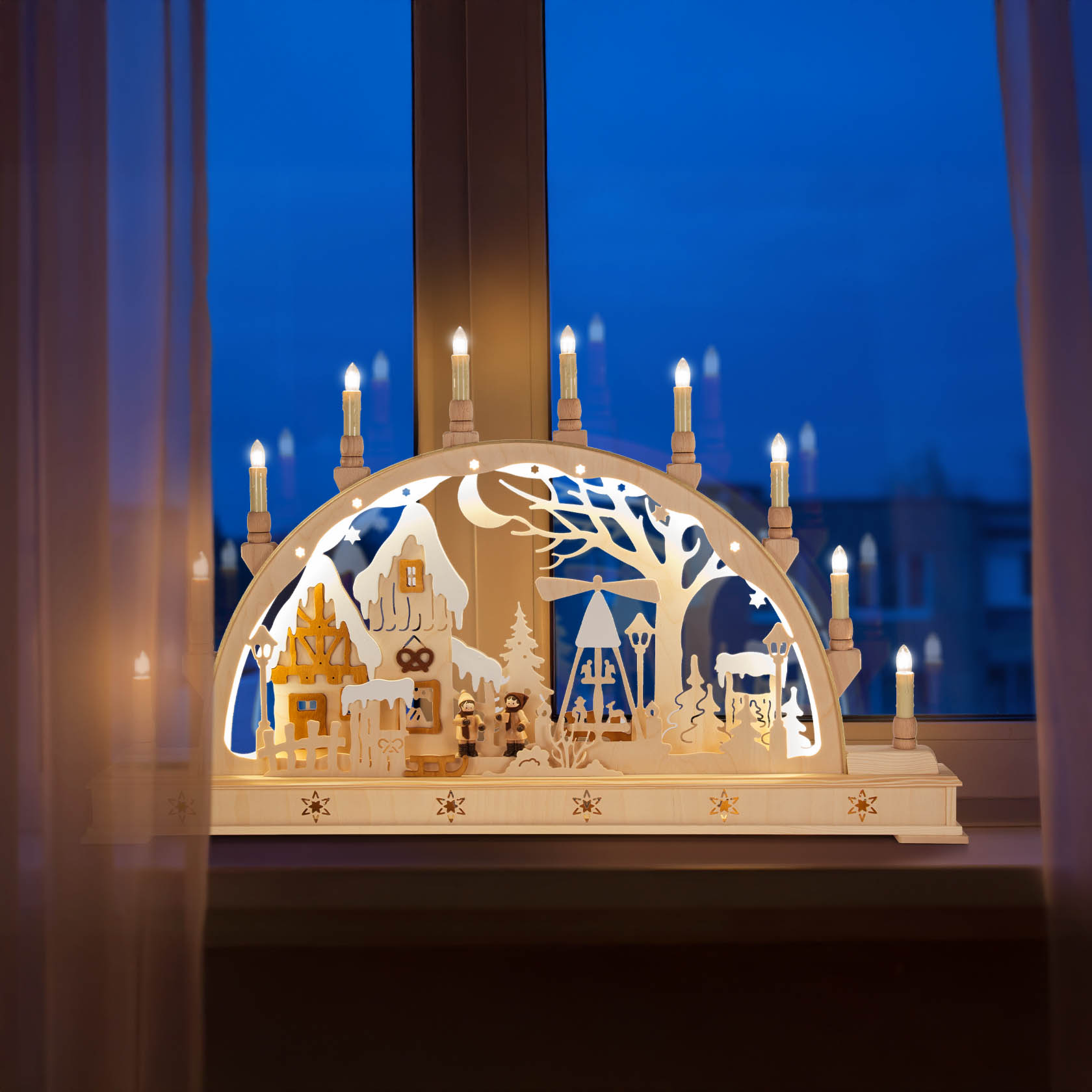 Ein elektrisch beleuchteter Schwibbogen mit Weihnachtsmarktszene. Zehn Lichter in Kerzenform umranden den Bogen, darunter winterliche Gebäude und Bäume.
