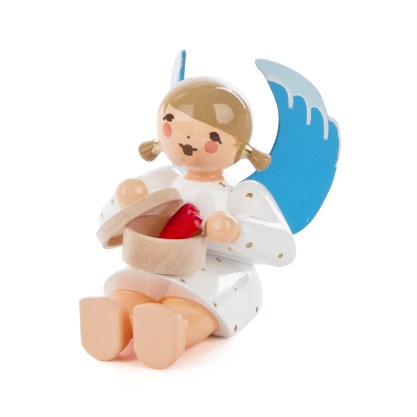 A wooden angel figurine smiling while sitting with a blue wing and polka-dotted dress, holding an open gift box with a red heart inside. im Dregeno Online Shop günstig kaufen
