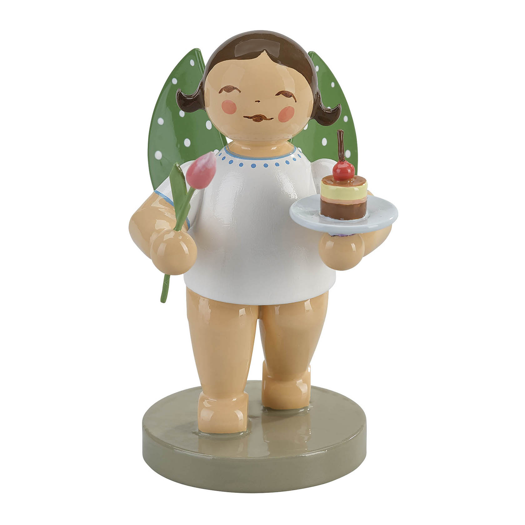 Holzfigur eines fröhlichen Engels mit braunen Locken und grün-weiß gepunkteten Flügeln. Der Engel hält eine Tulpe in der linken Hand und ein Törtchen auf einem Teller in der rechten Hand. im Dregeno Online Shop günstig kaufen