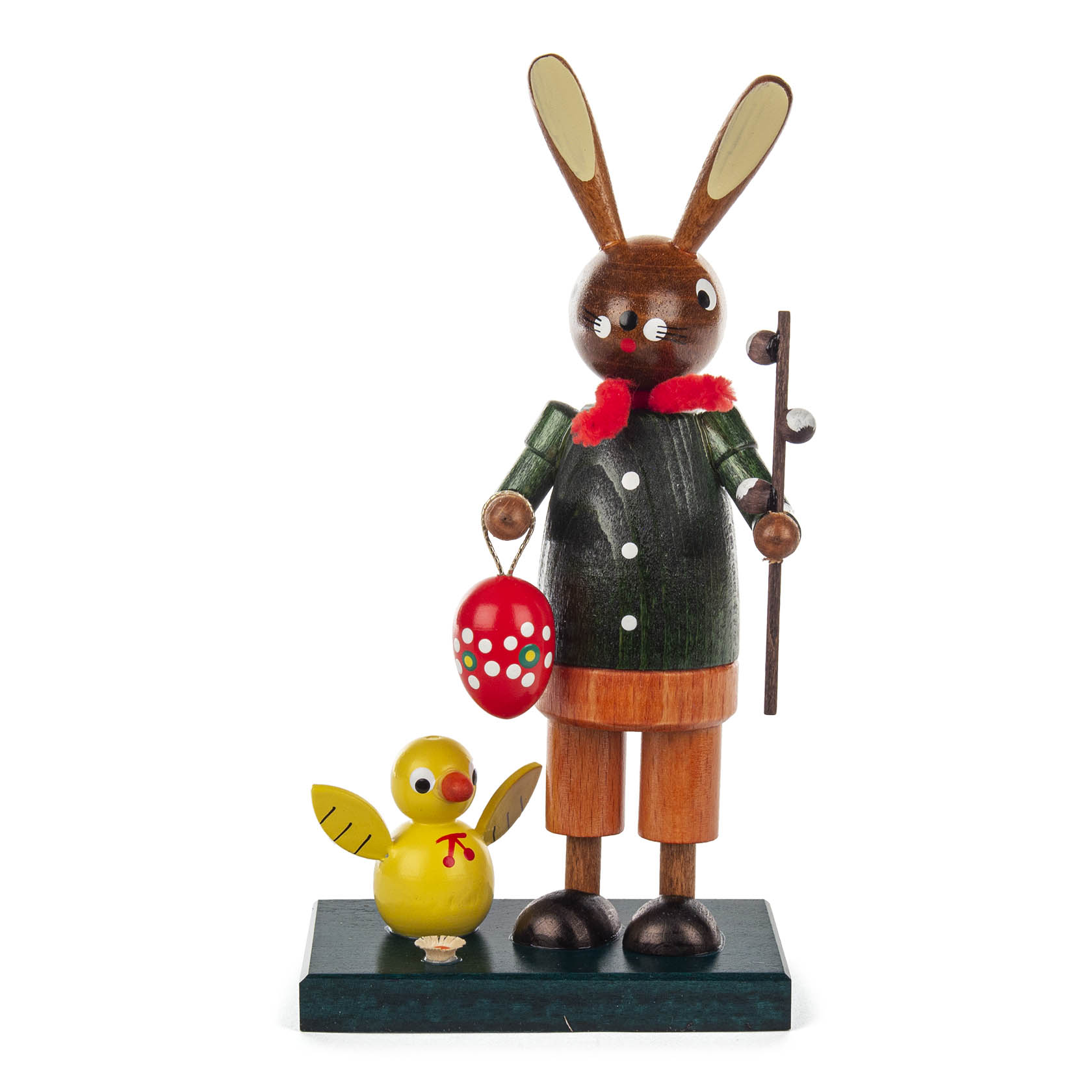Holzfigur eines Osterhasen in grünem Mantel, hält bemaltes rotes Osterei und steht neben gelbem Küken. im Dregeno Online Shop günstig kaufen