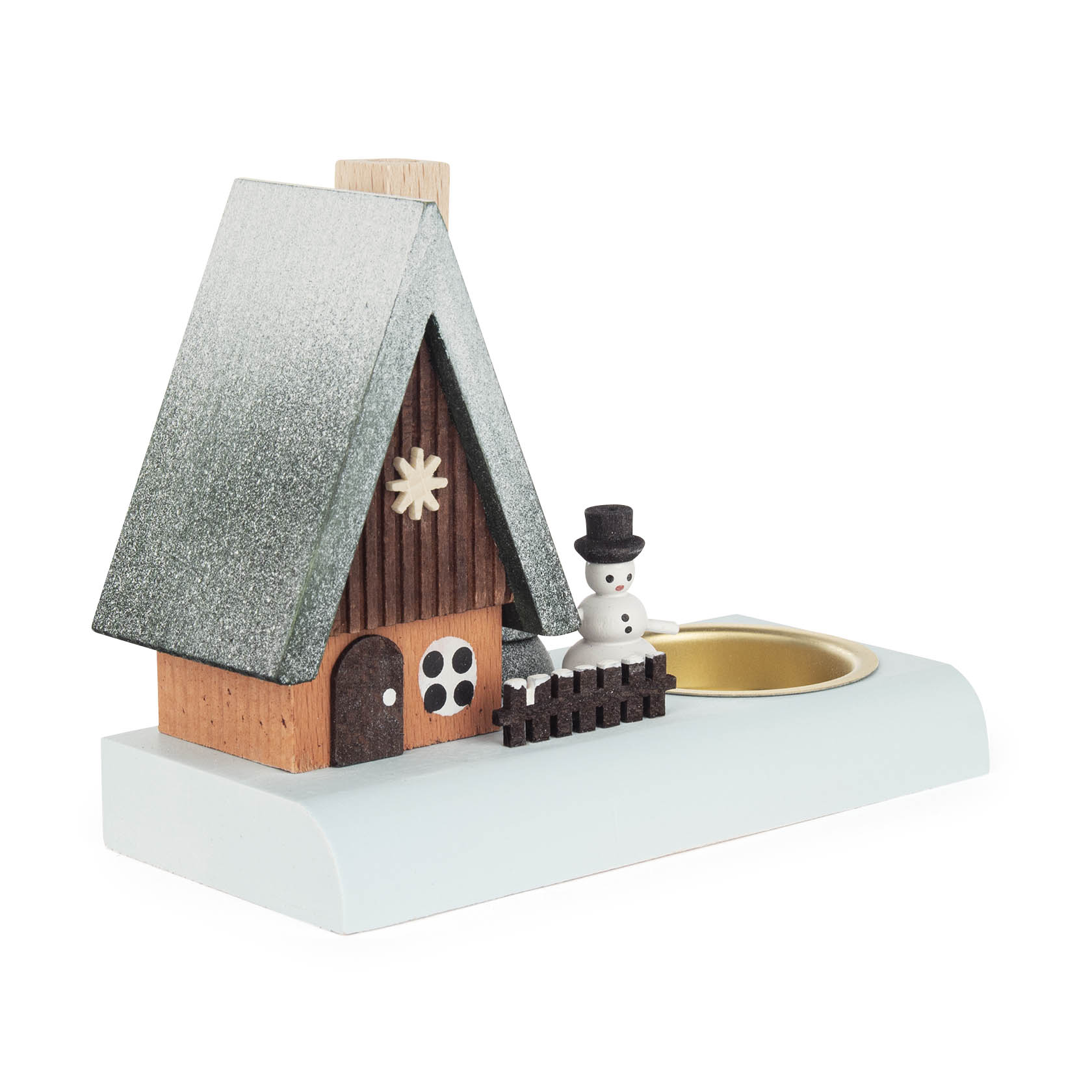 Ein Teelichthalter aus Holz mit einem kleinen hölzernen Räucherhaus, einem Schneemann und einem Tannenbaum neben einem Teelichtplatz auf einer weißen Basis.