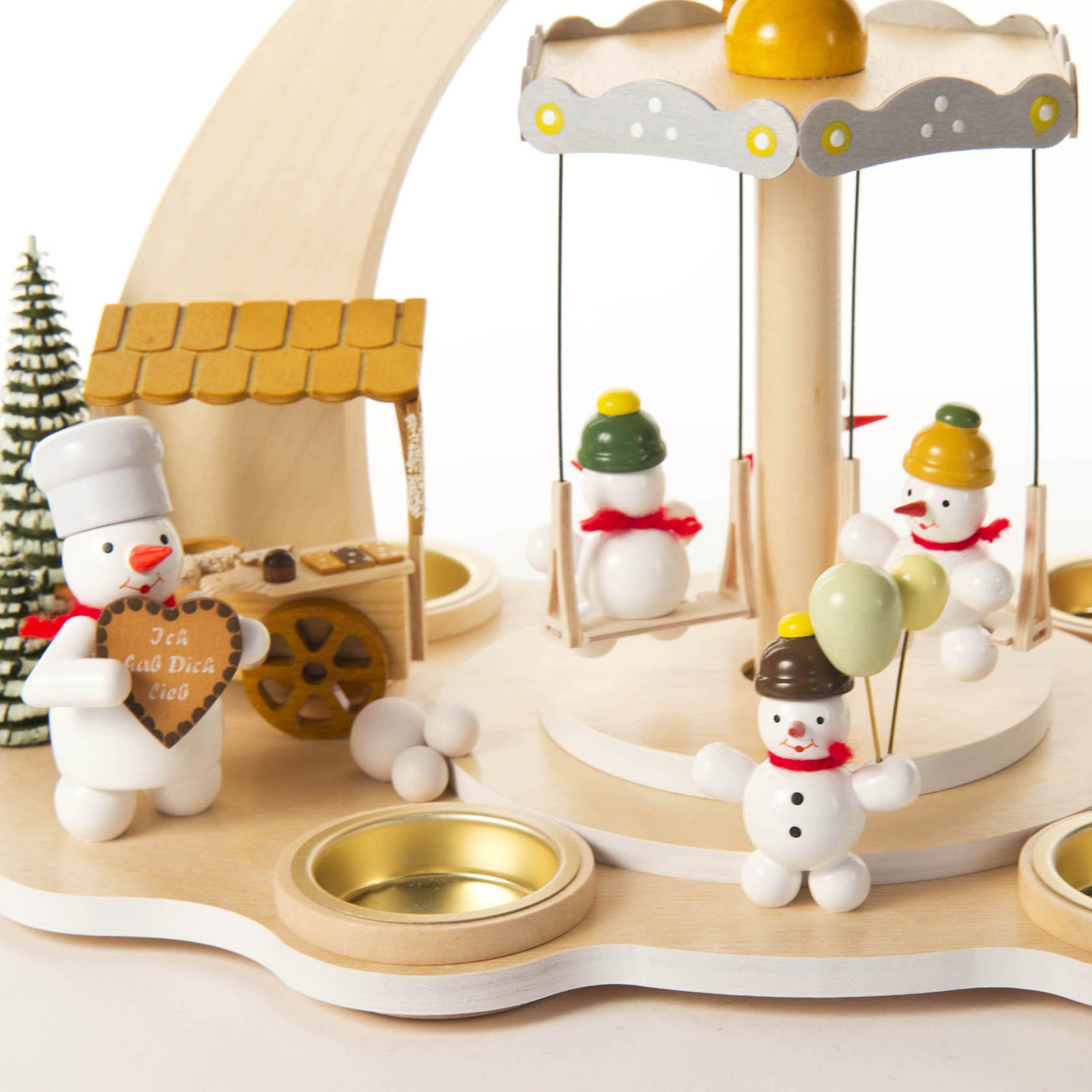Holzpyramide mit Schneemann-Figuren und Karussell für Teelichte. Ein Schneemann hält Luftballons, ein anderer steckt in einer Schaukel und einer trägt ein Herz.