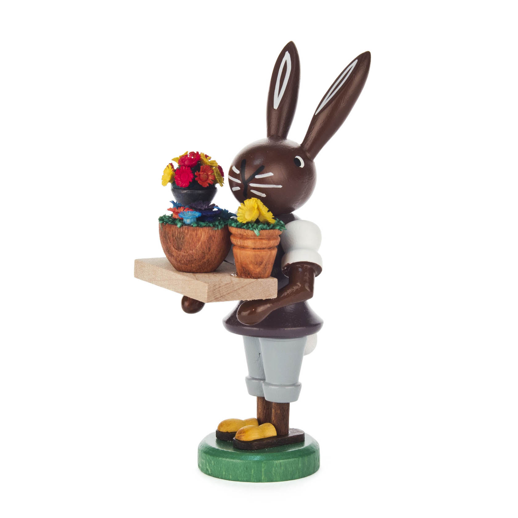 Holzfigur eines Hasen mit braunem Fell, der ein weißes Hemd und kurze Hosen trägt. Der Hase hält ein Tablett mit zwei Blumentöpfen, die bunte Blumen enthalten. im Dregeno Online Shop günstig kaufen