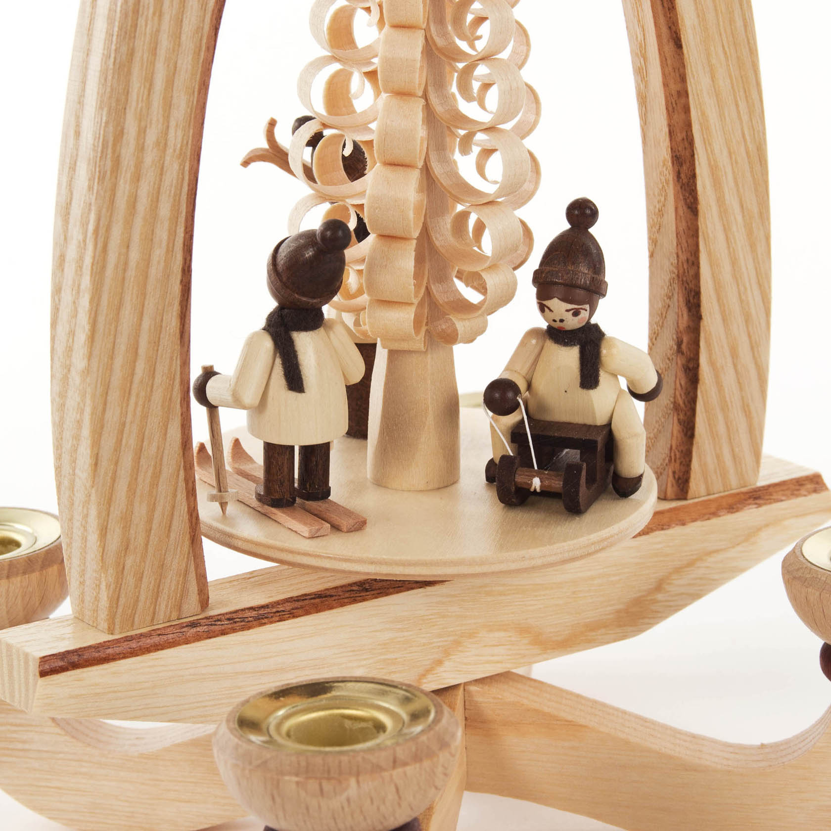 Holzpyramide mit Figuren von zwei Kindern in Winterkleidung; eins auf Skiern, das andere auf einem Schlitten. Platz für Kerzen mit Durchmesser 14mm.