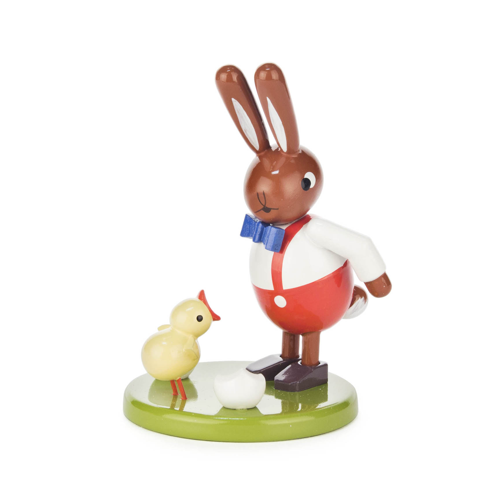 Dekorative Holzfigur: Braun-weißer Hase mit blauem Schleifenband und roten Hosen, steht neben gelbem Küken auf grünem Sockel. im Dregeno Online Shop günstig kaufen