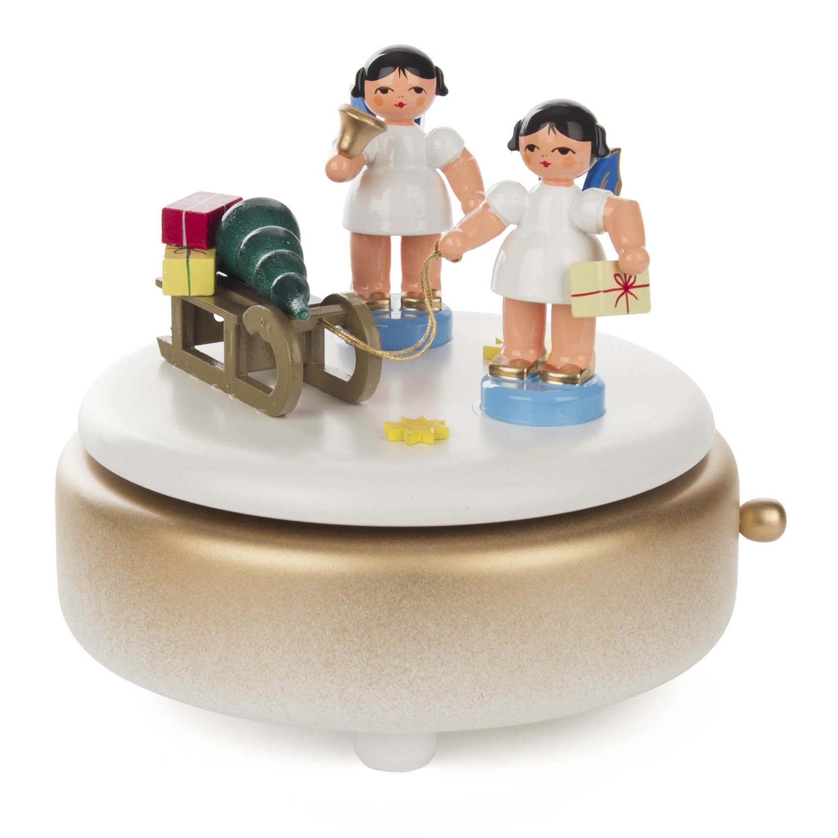 Weiße und goldene Spieldose mit zwei Engeln. Ein Engel hält eine Glocke, der andere ein Geschenk. Daneben ein Schlitten mit Weihnachtsbaum und Geschenken. im Dregeno Online Shop günstig kaufen