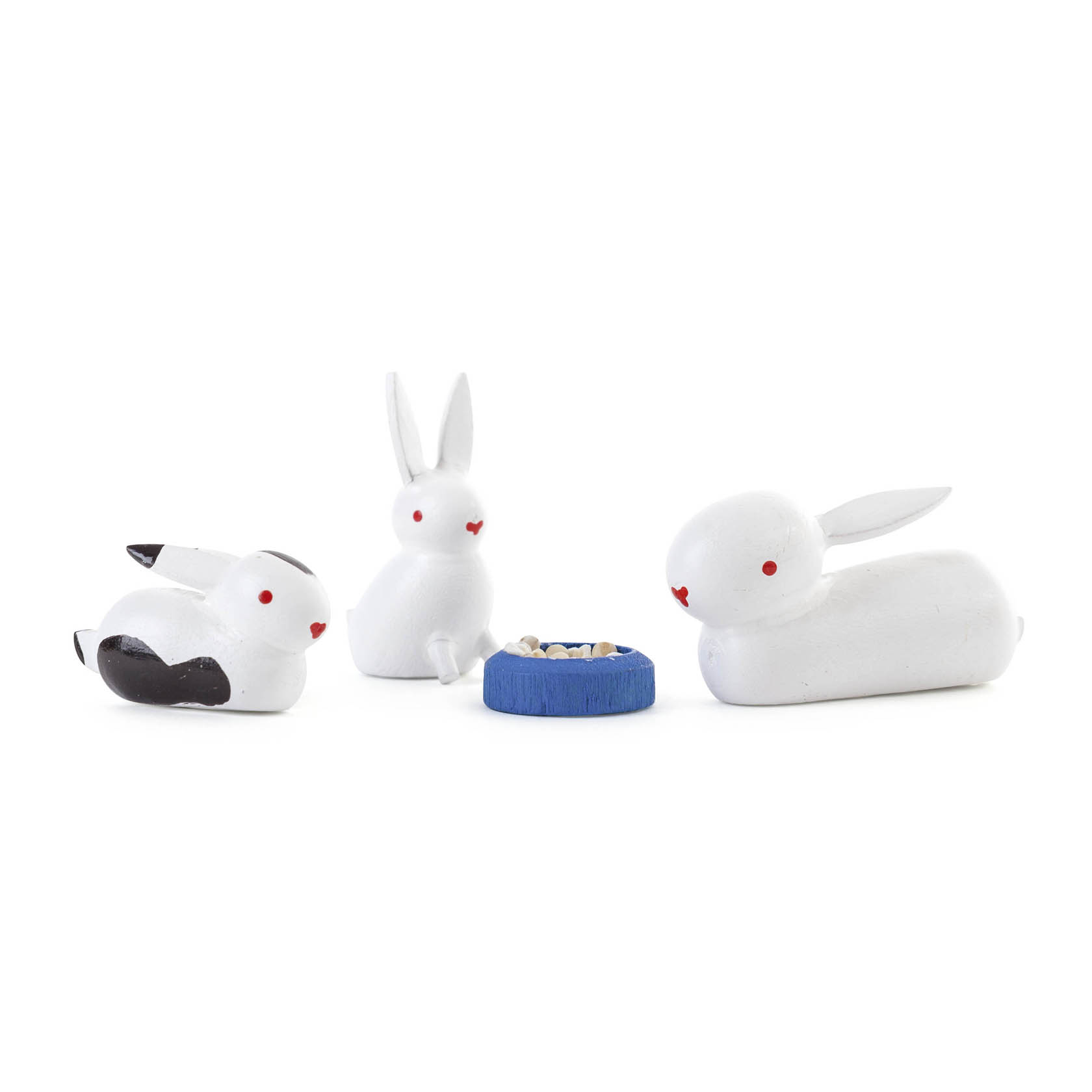 Drei weiße Kaninchen mit roten Augen: zwei sitzen, eines liegt. In der Mitte ein blaues Napf mit Körnern. im Dregeno Online Shop günstig kaufen