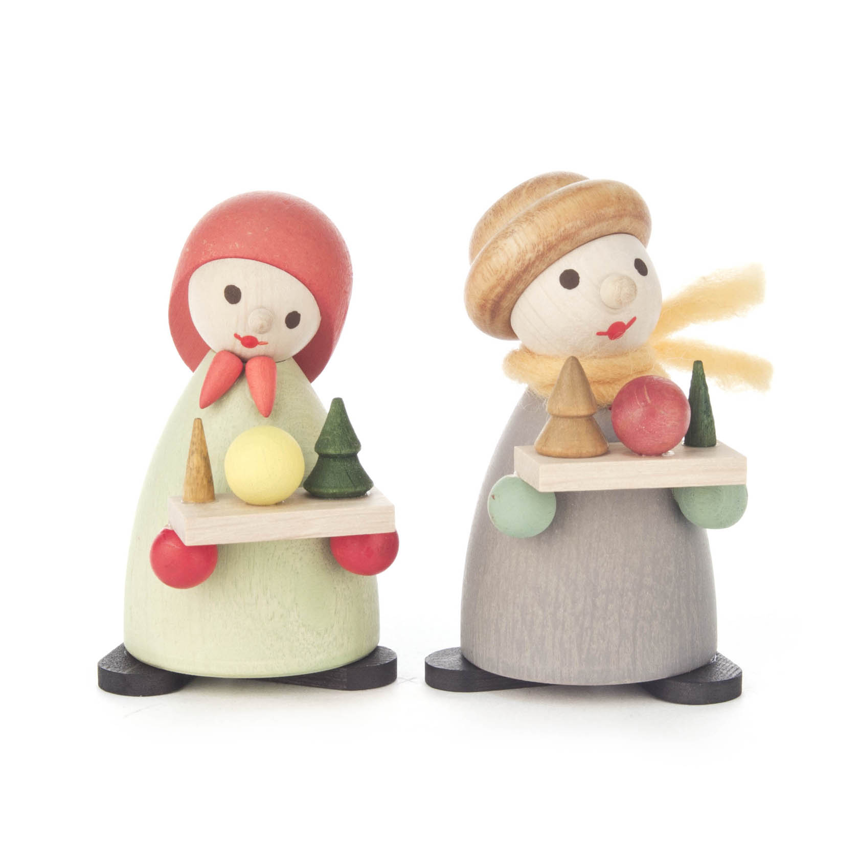 Zwei moderne Holzfiguren, bekannt als Striezelkinder, in Pastelltönen. Die linke Figur trägt ein rotes Kopftuch, die rechte eine beige Mütze.