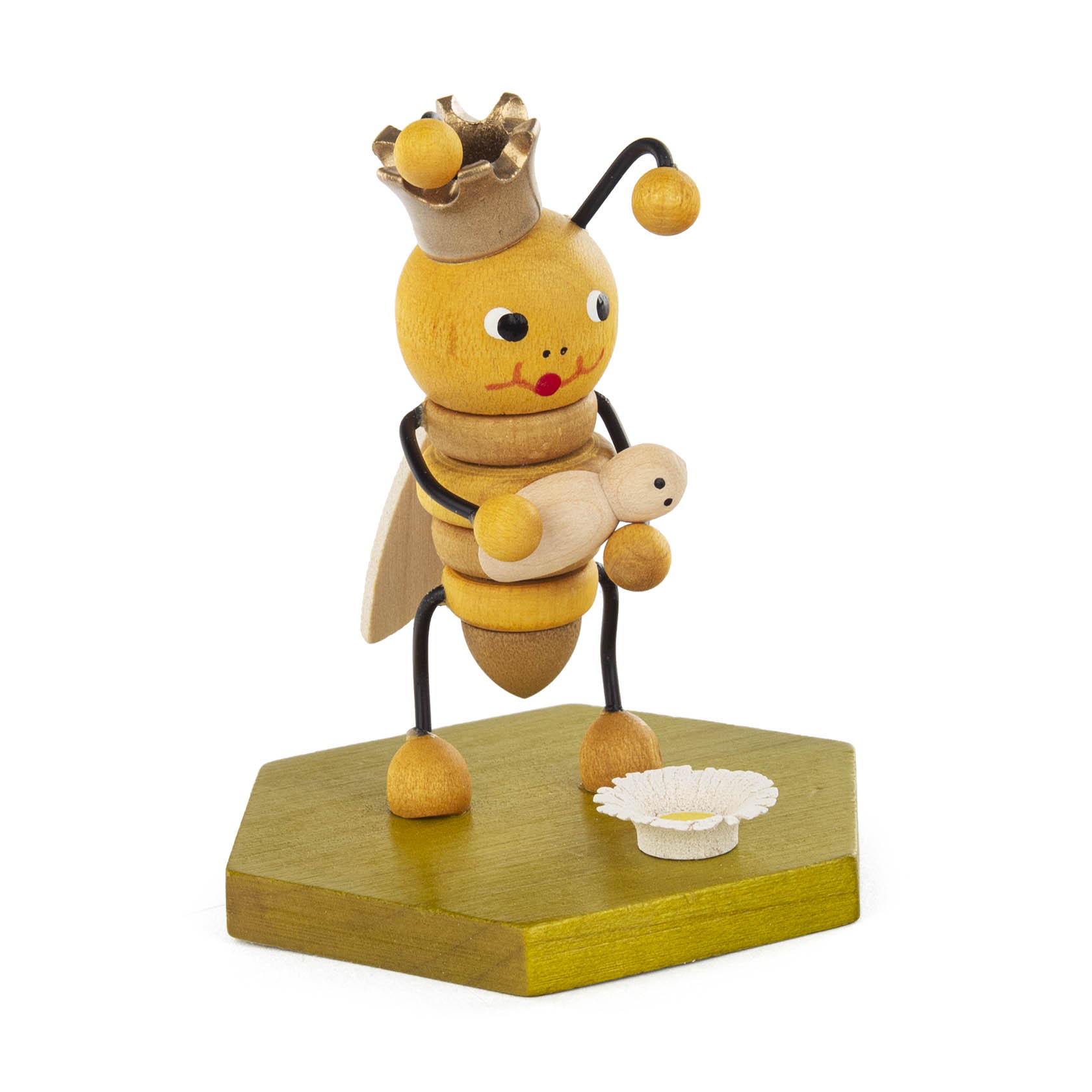Holzfigur einer Bienenkönigin mit goldener Krone, die ein Baby in den Händen hält. Sie steht auf einer sechseckigen, grünen Plattform neben zwei weißen Blumen. im Dregeno Online Shop günstig kaufen