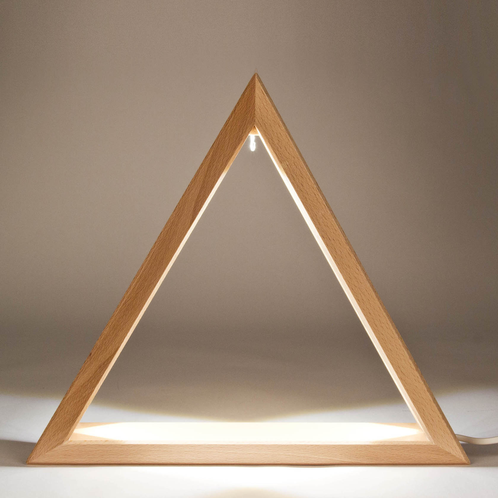 Ein beleuchtetes Dreieck aus hellem Holz mit einem integrierten LED-Band. Die Form ist gleichseitig und das Licht strahlt gleichmäßig nach innen.