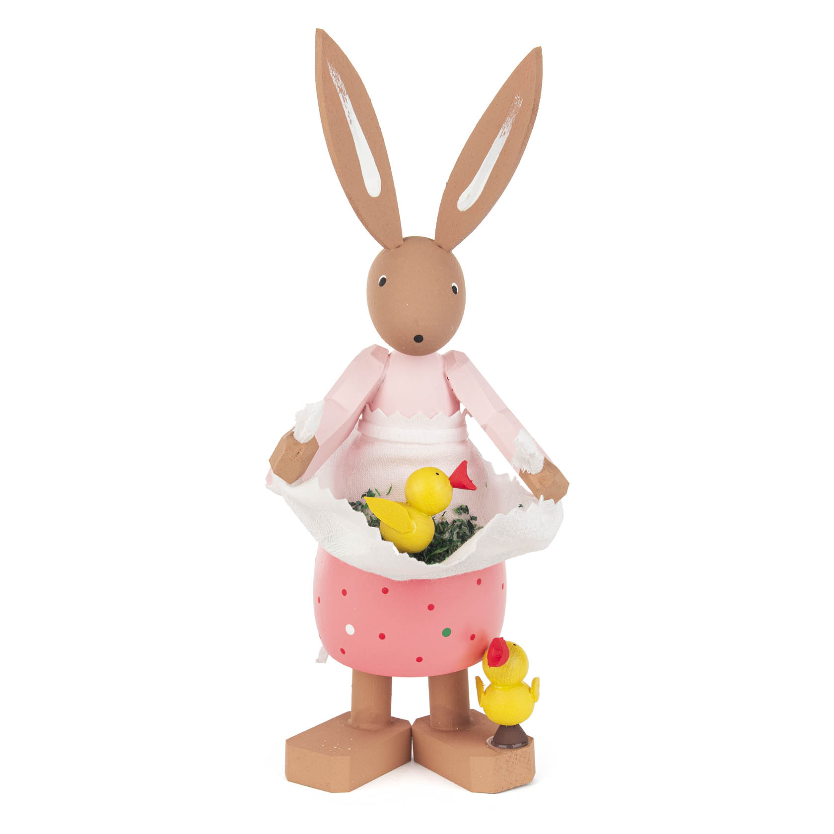 Holzfigur eines schlanken Osterhasen namens Hanni, der ein rosa Kleid trägt und ein weißes Tuch hält, in dem zwei gelbe Küken sitzen. im Dregeno Online Shop günstig kaufen