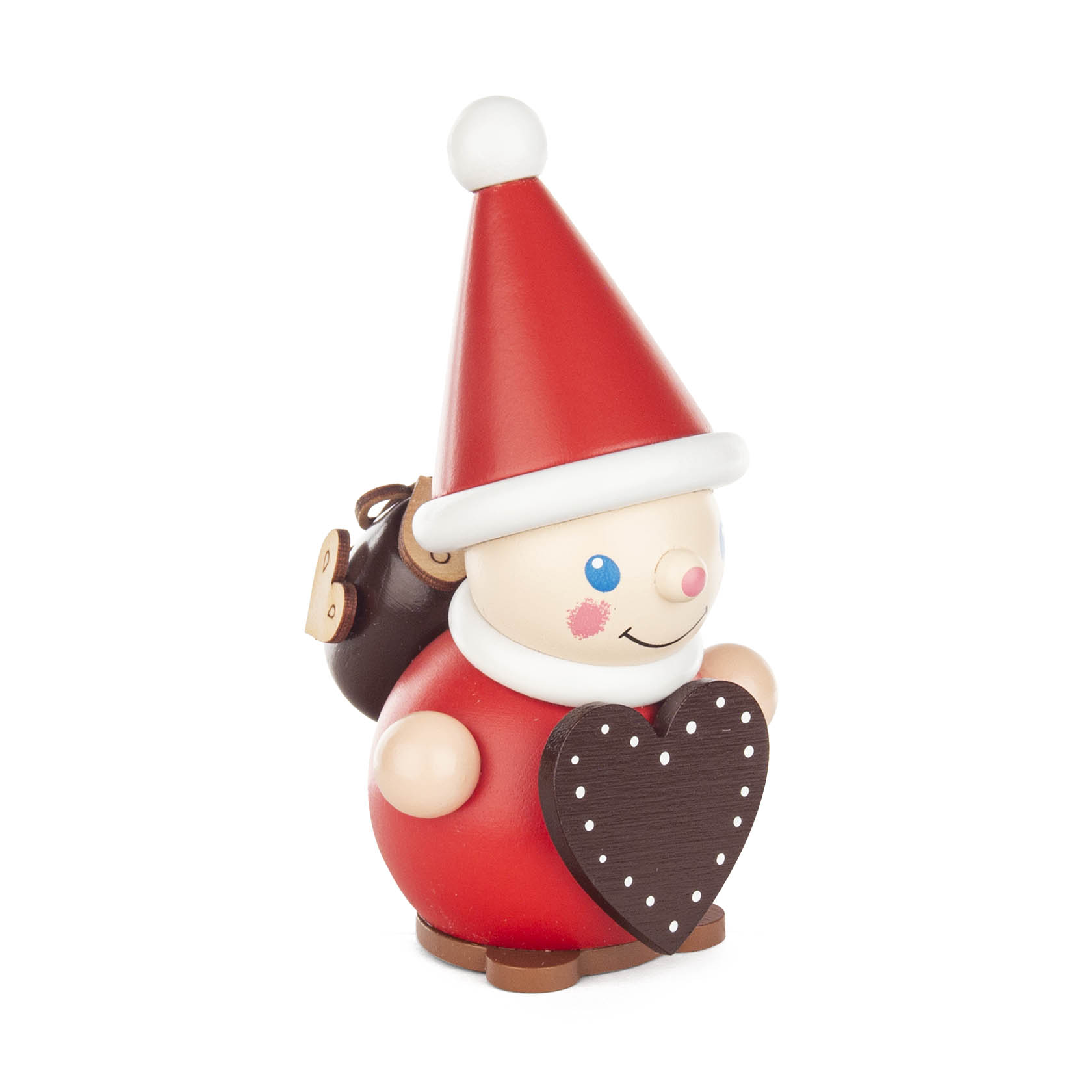 Fröhlicher Wichtel mit roter Kappe hält ein Herz aus Lebkuchen in den Händen und trägt einen Rucksack. im Dregeno Online Shop günstig kaufen