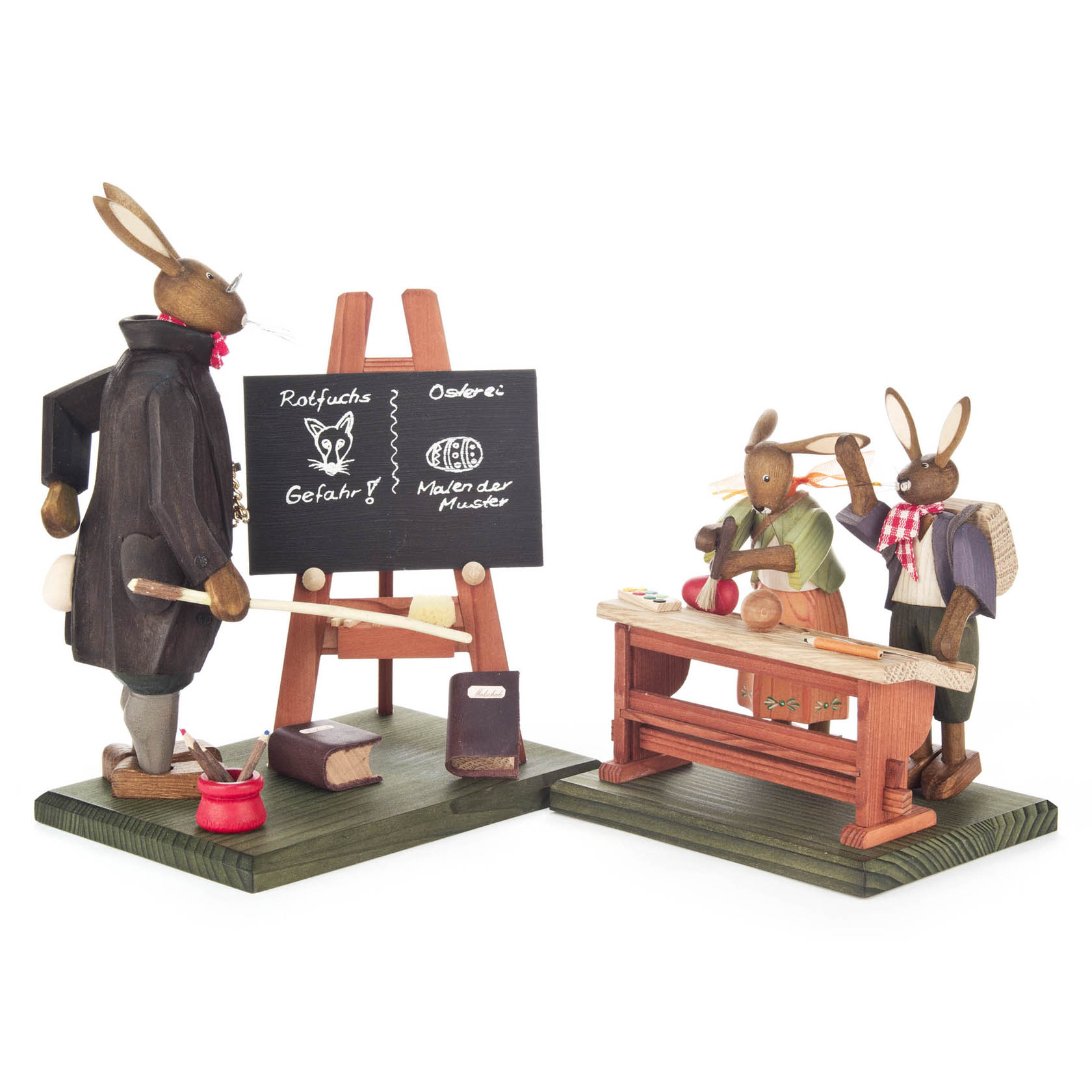 Holzfiguren einer Hasenlehrerin, die an einer Tafel über Rotfüchse unterrichtet, und zwei Hasenschüler, die an einem Tisch Notizen machen. im Dregeno Online Shop günstig kaufen