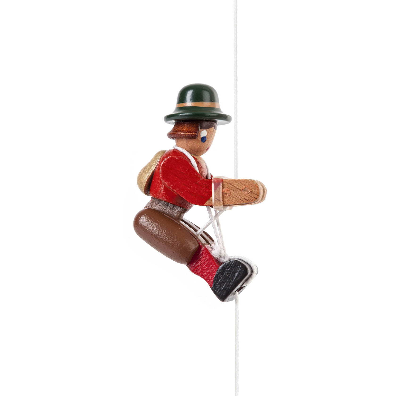 Eine handgefertigte Kletterfigur einer Bergsteigerin in traditioneller Kleidung mit grünem Hut und rotem Hemd, die an einem Seil hängt. im Dregeno Online Shop günstig kaufen