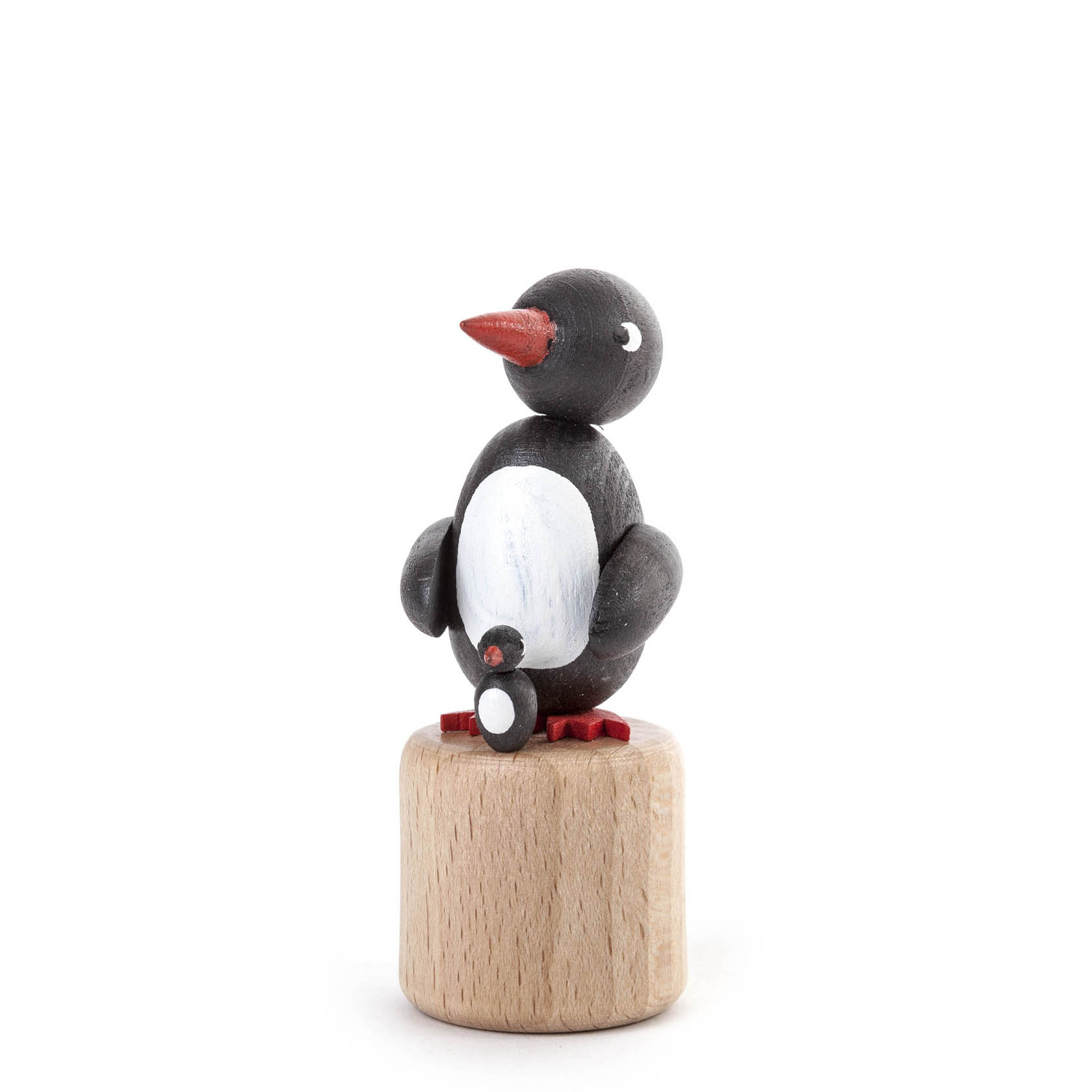 Holzpinguin mit rotem Schnabel und Flügeln auf einer runden Basis, die als Wackeltier fungiert. im Dregeno Online Shop günstig kaufen