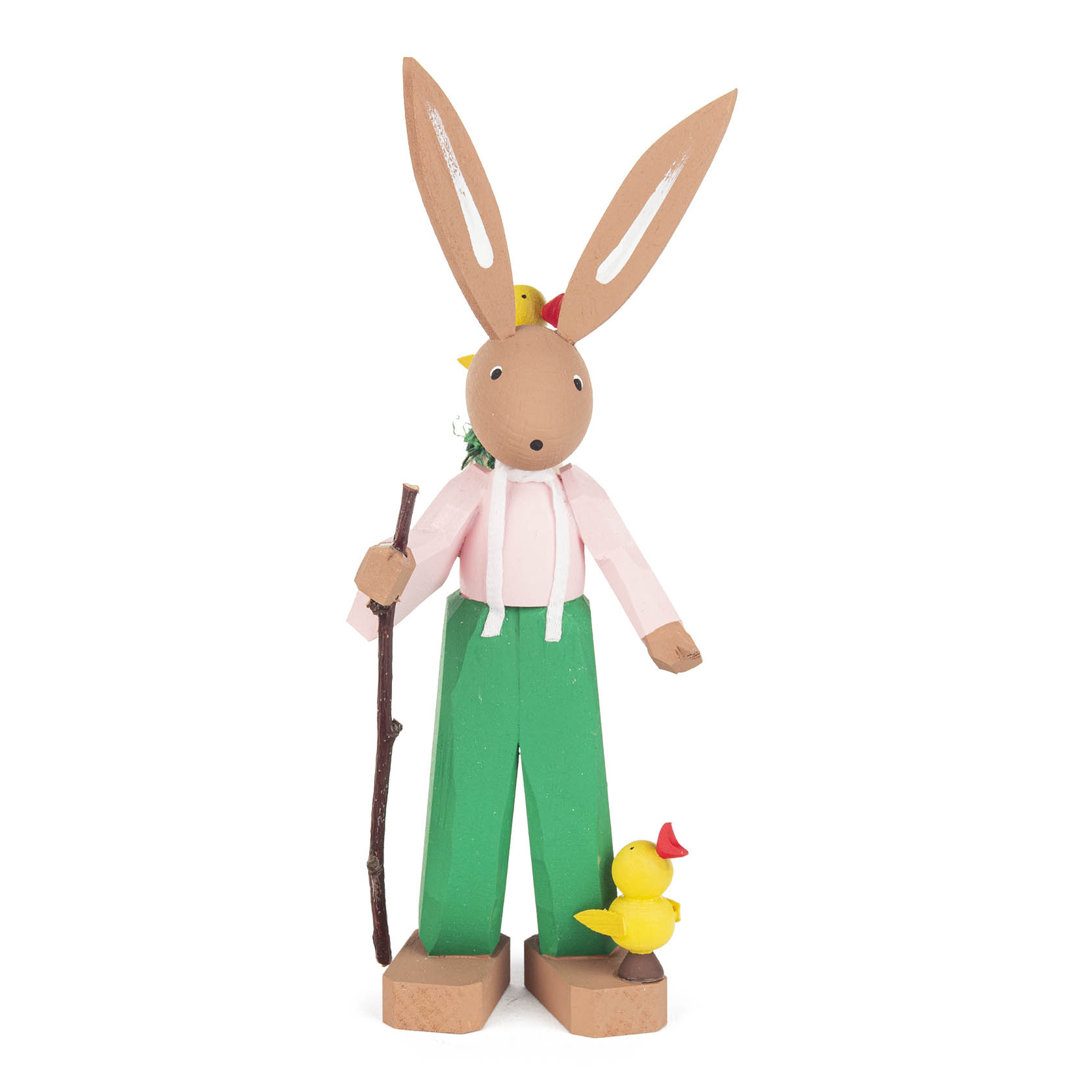 Holzfigur eines Osterhasen namens Hugo mit langen Ohren, rosa Hemd, grüner Hose und braunen Schuhen. Er hält einen Wanderstock und hat ein gelbes Küken zu Füßen. im Dregeno Online Shop günstig kaufen