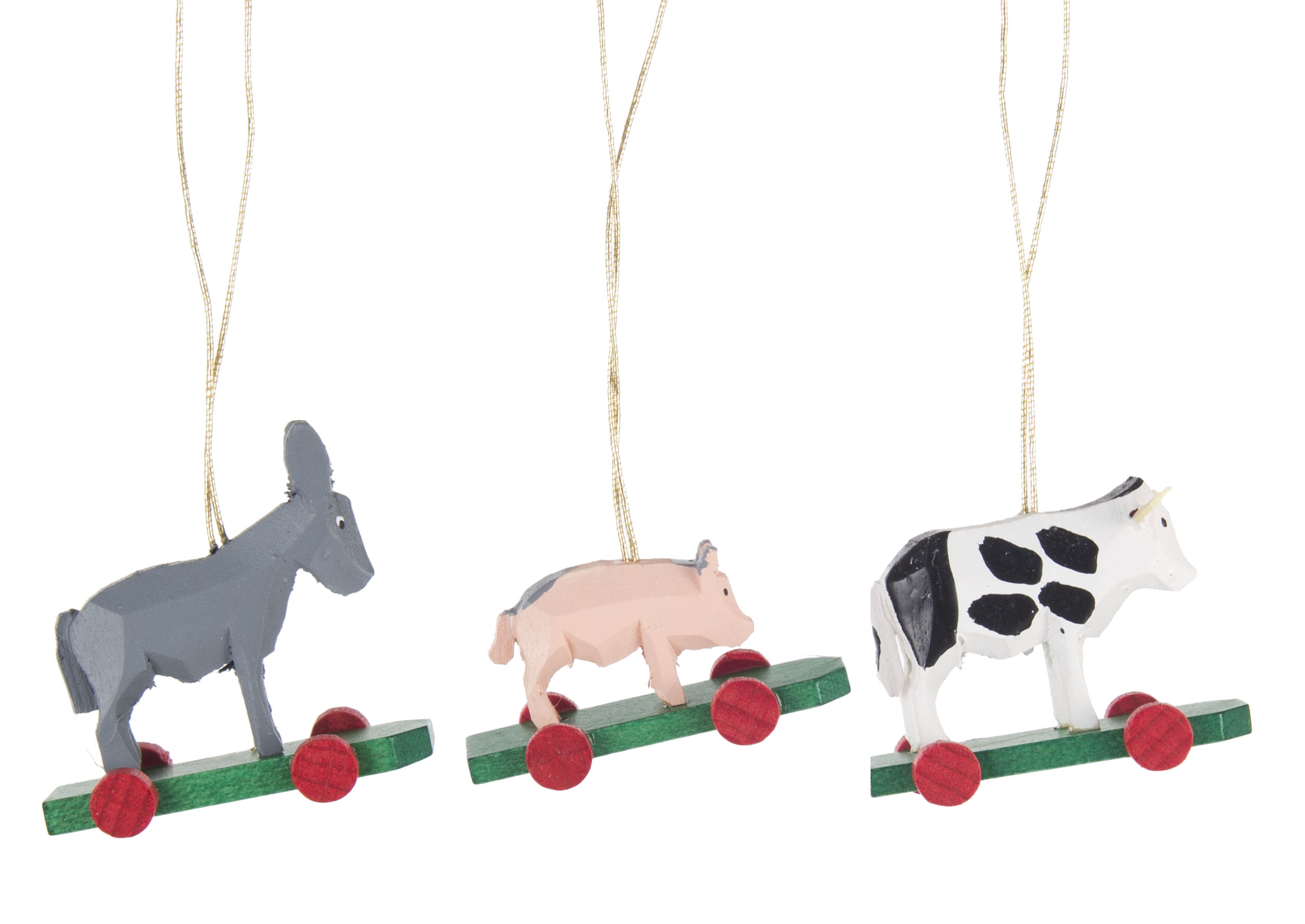 Holzfiguren von Tieren auf Rädern: Ein grauer Esel, ein rosa Schwein und eine schwarz-weiße Kuh hängen an goldenen Schnüren.