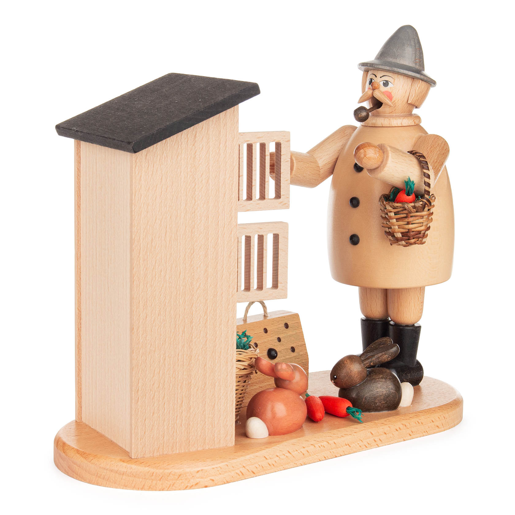 Holzfigur eines Kaninchenzüchters mit Pfeife, Hut und Stock, stehend neben einem Kaninchenstall. Vor ihm sind zwei Kaninchen und eine Möhre. im Dregeno Online Shop günstig kaufen